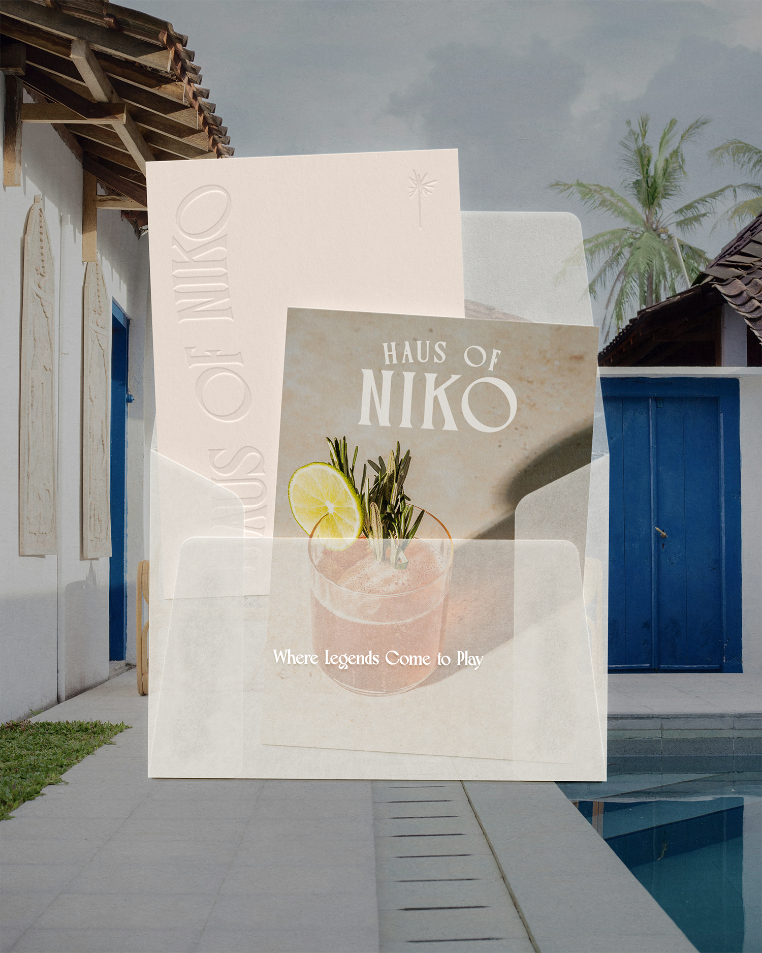 A promotional display for Haus of Niko featuring a cocktail with lemon slices, herbs, and the text 'Where Legends Come to Play' in front of a house with a swimming pool and palm trees.