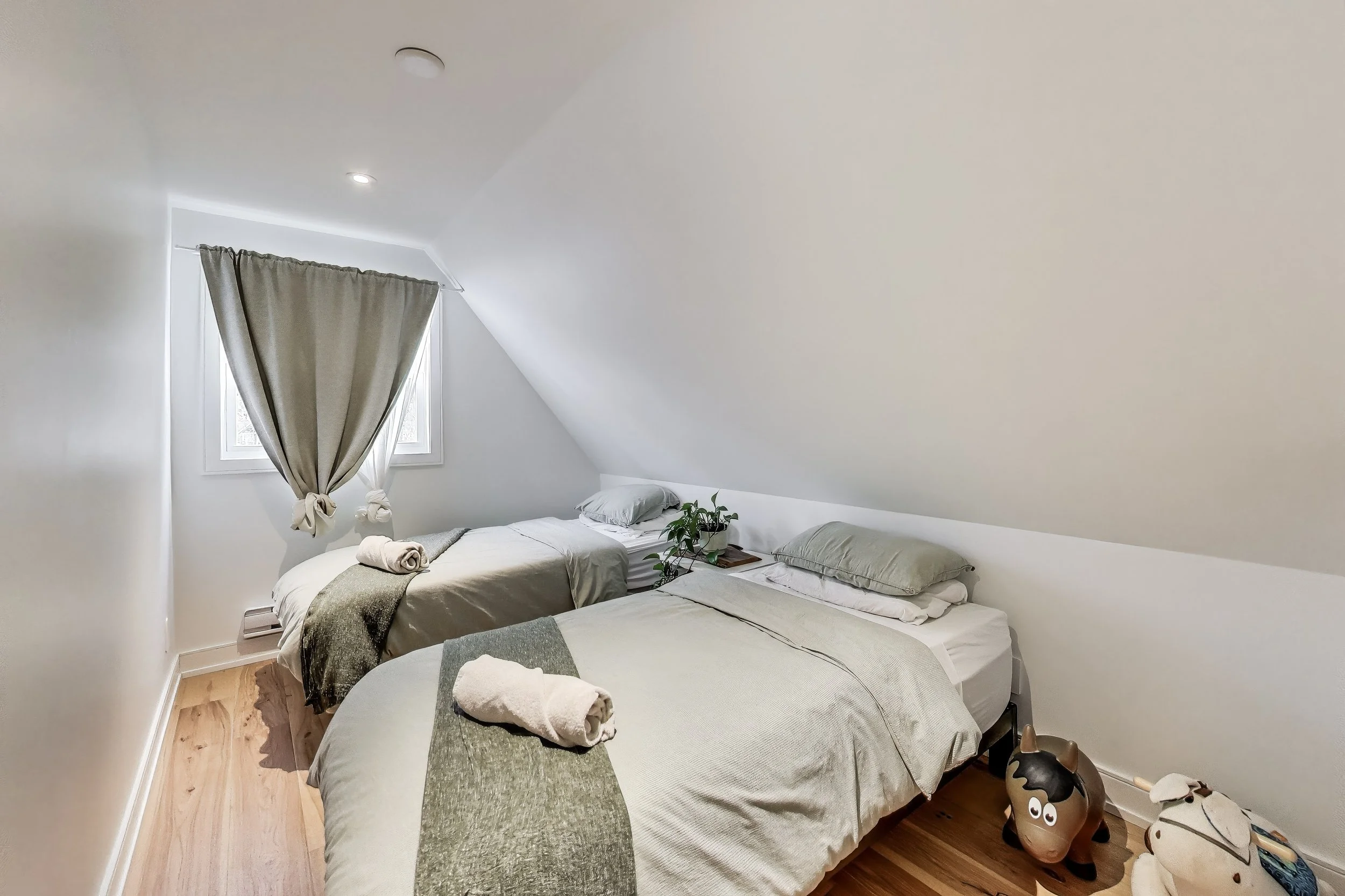 Cozy and inviting bedroom in Muskoka A-frame cottage, featuring comfortable bedding and rustic charm — the perfect retreat for restful nights after a day of outdoor adventures in Ontario’s cottage country.