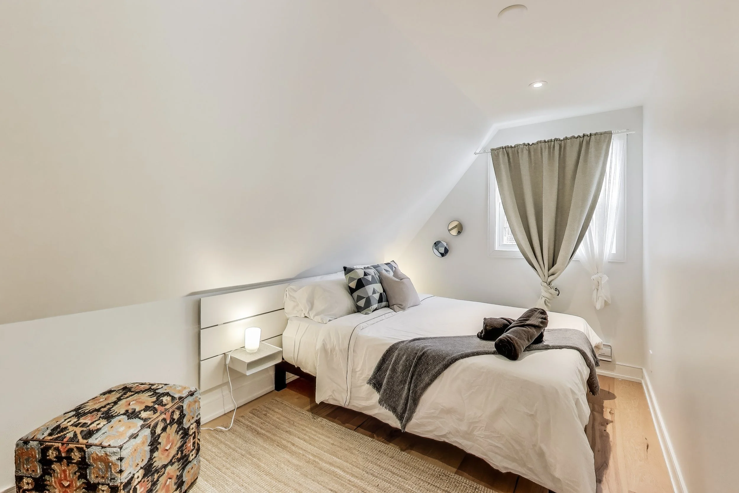 Cozy and inviting bedroom in Muskoka A-frame cottage, featuring comfortable bedding and rustic charm — the perfect retreat for restful nights after a day of golfing and outdoor adventures in Ontario’s cottage country.