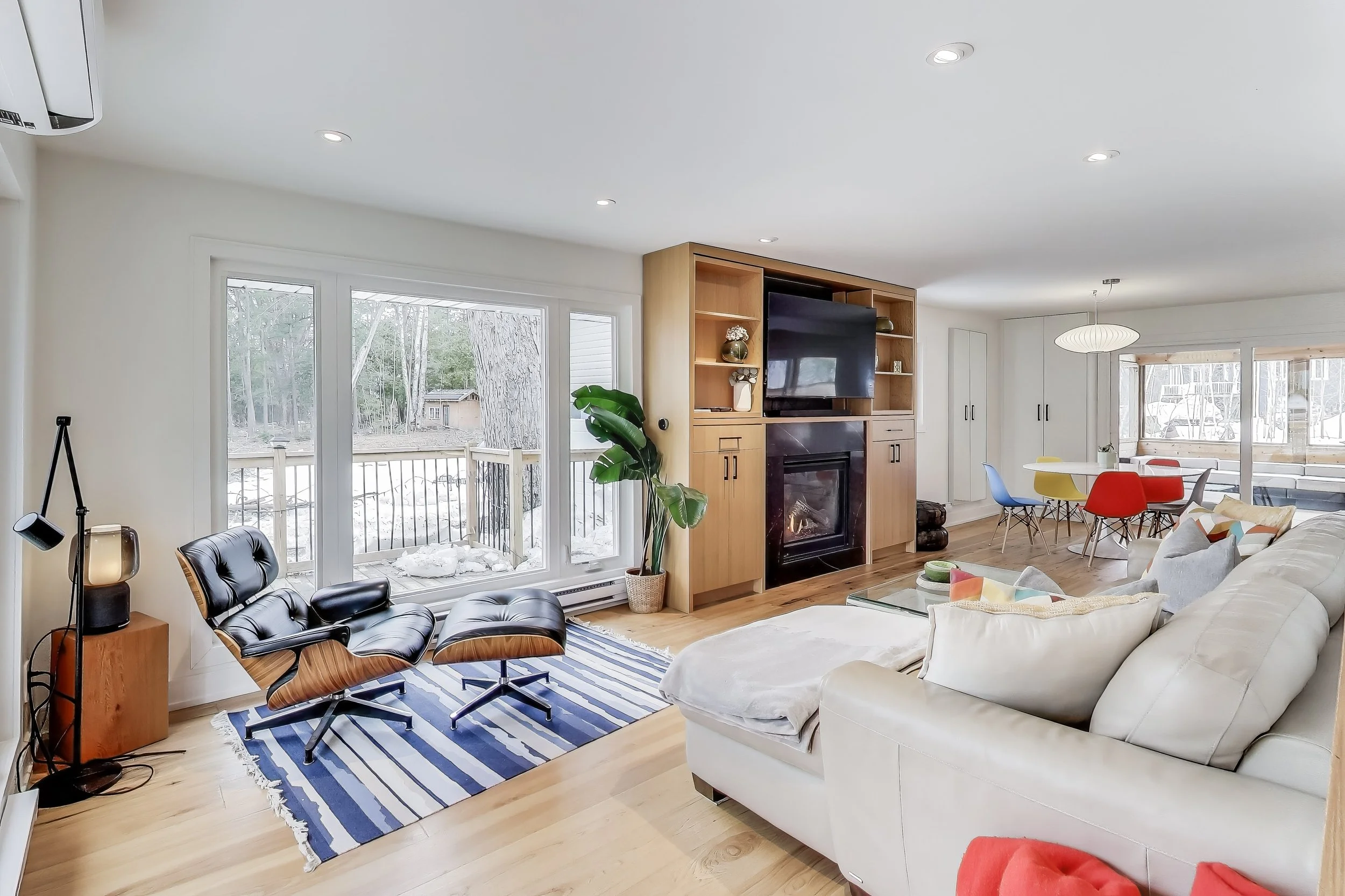 Renovated living room in Muskoka A-frame cottage featuring modern furnishings, large windows with lake views, and a cozy, open-concept design — perfect for relaxing and enjoying family time in Ontario's cottage country.