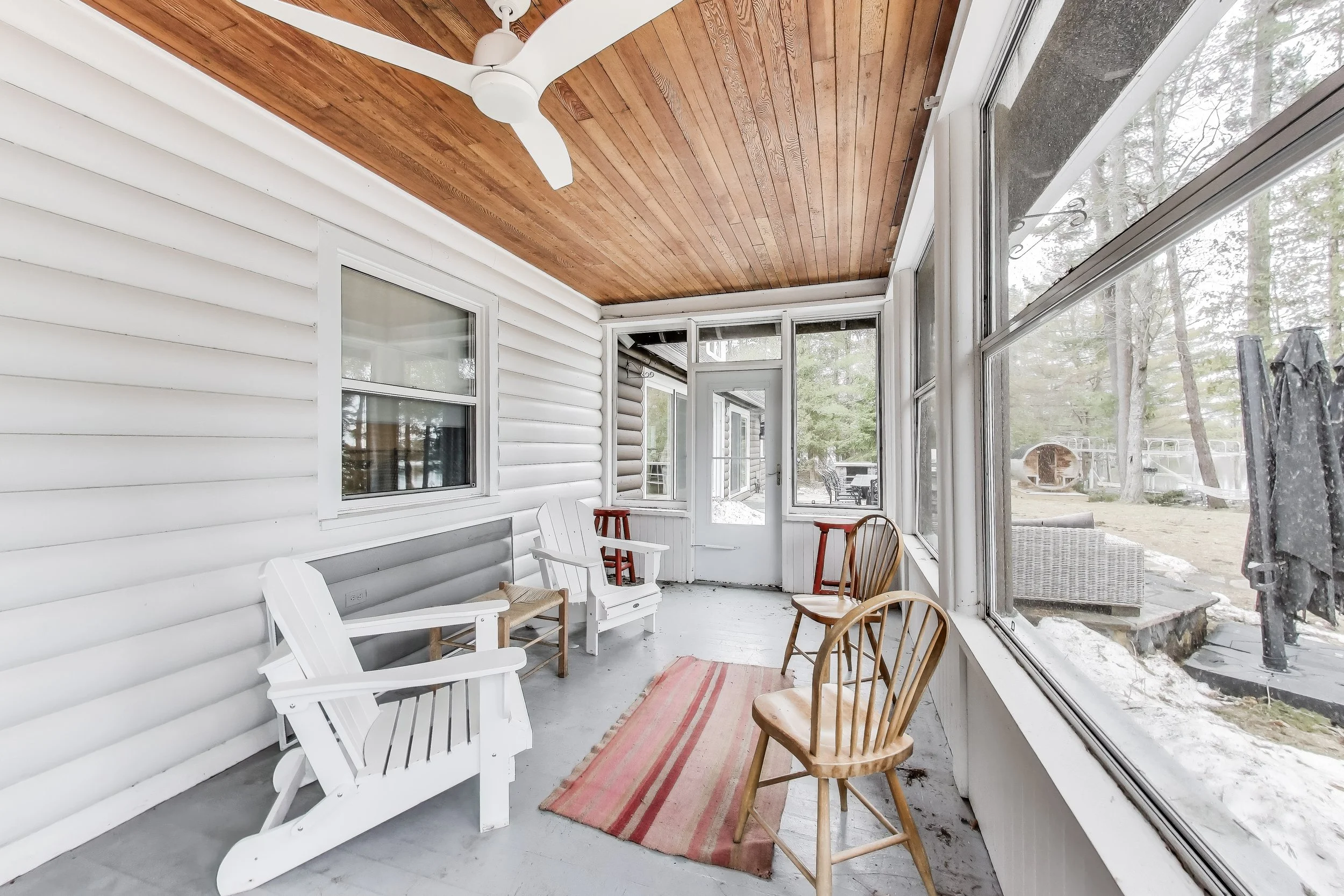 Relaxing covered porch offering a shaded space to unwind and enjoy the outdoors—ideal for sipping coffee, reading, or enjoying the fresh air in Ontario’s cottage country.