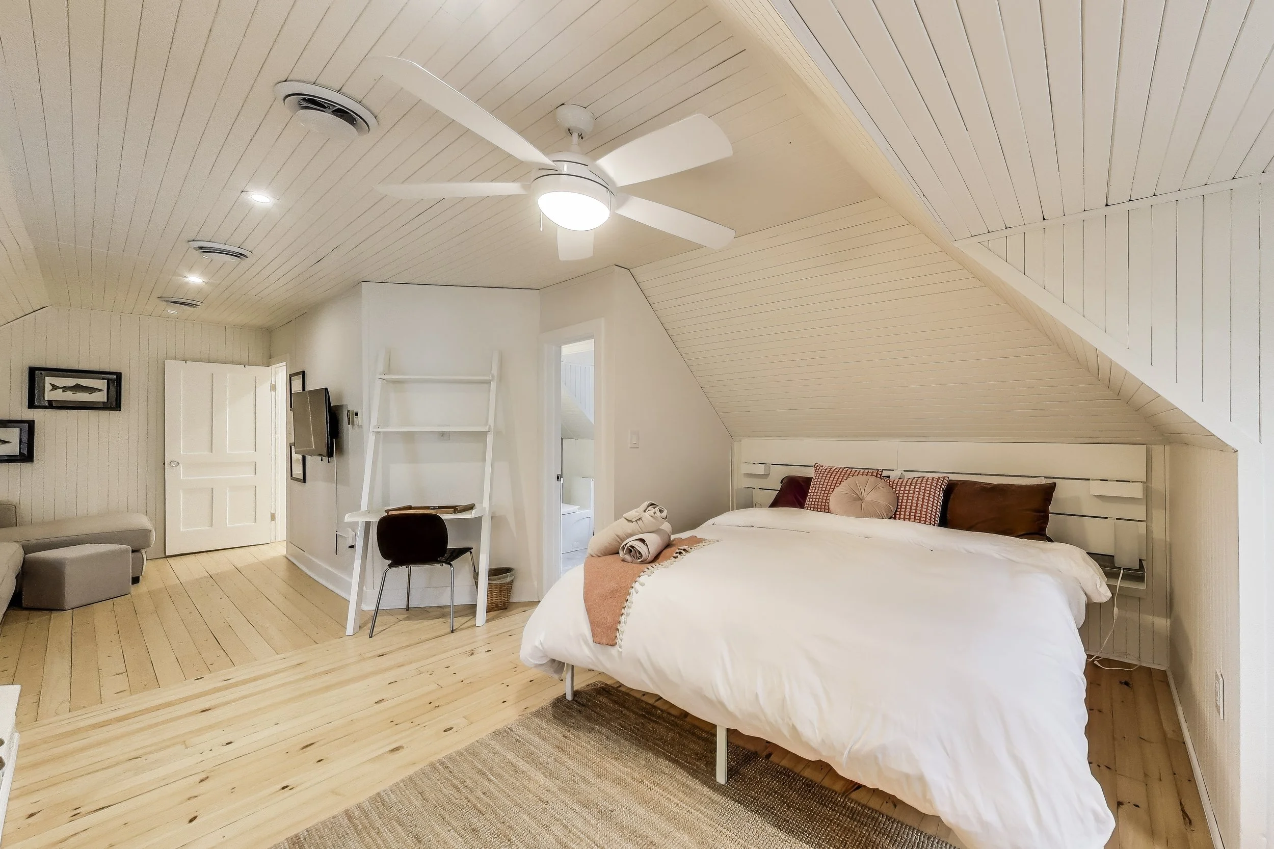 Spacious master bedroom, featuring a large bed and serene décor—ideal for unwinding after a day of golf or lakefront activities in Ontario’s cottage country.