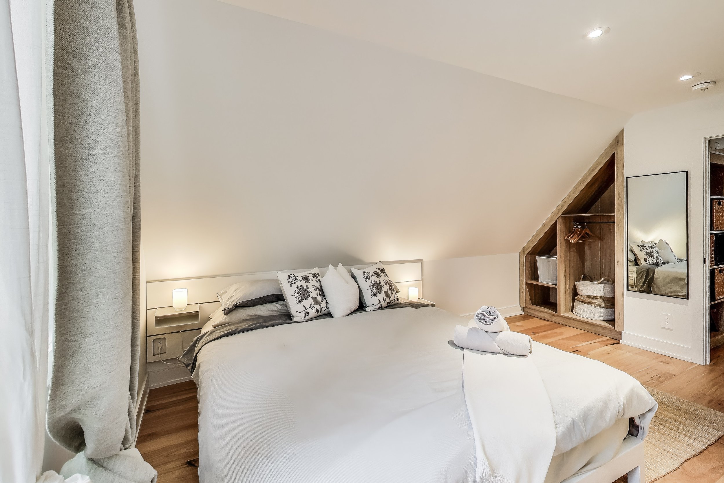 Cozy and inviting bedroom in Muskoka A-frame cottage, featuring comfortable bedding and rustic charm — the perfect retreat for restful nights after a day of golfing and outdoor adventures in Ontario’s cottage country.