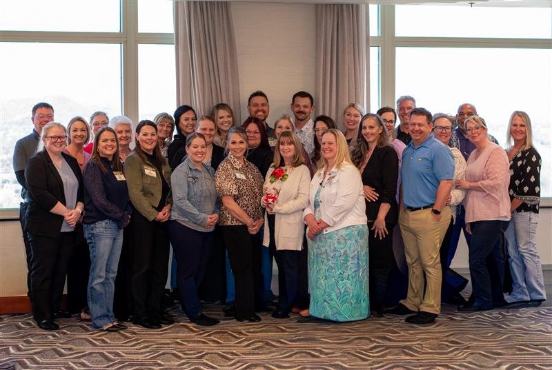Group of diverse professionals gathered indoors for a photo.
