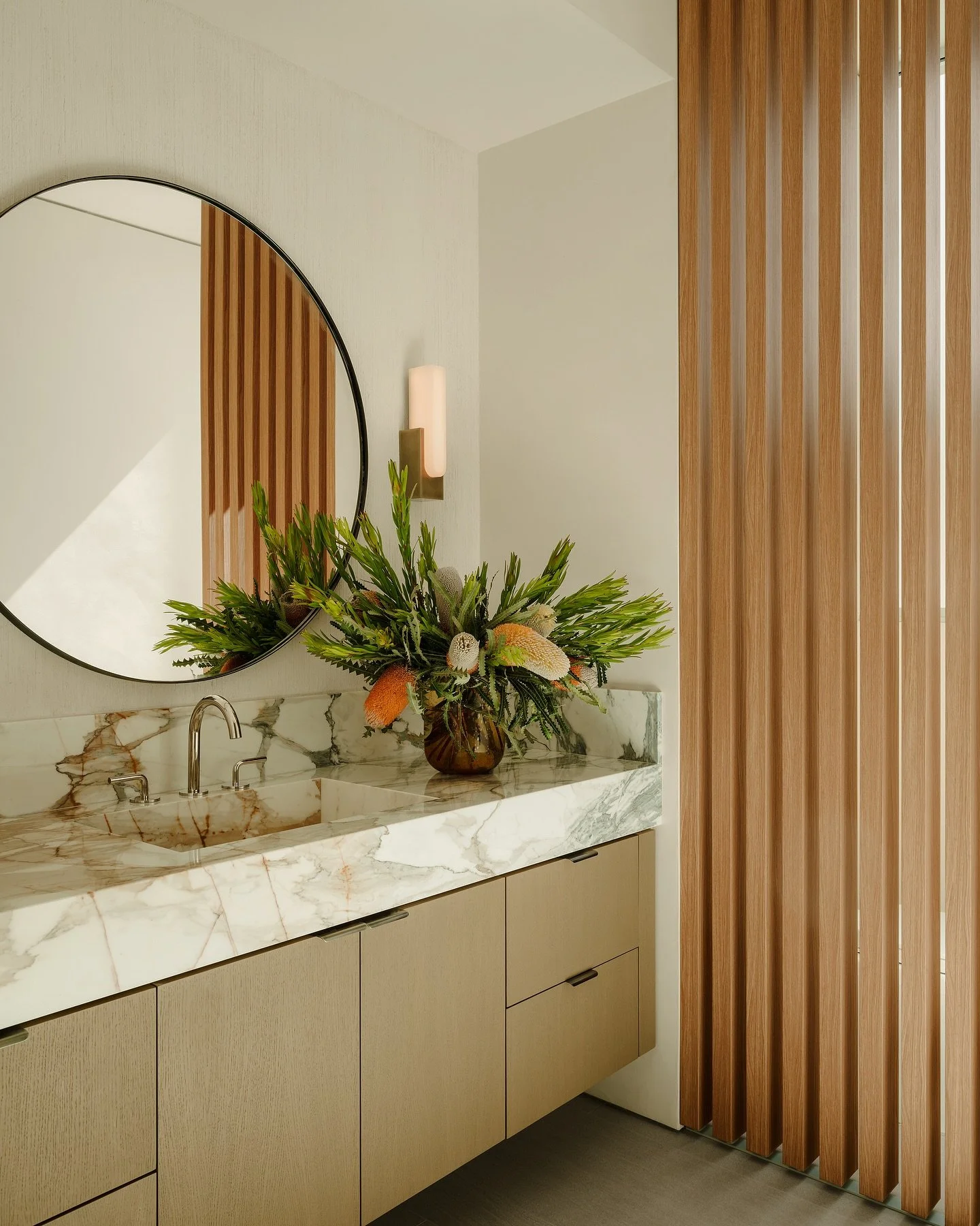 privacy, but make it pretty. ✨

In the powder room, a wood batten screen takes the place of a full enclosure&mdash;preserving natural light while adding warmth and dimension. Paonazzo marble adds beautiful movement, while nickel accents act like jewe