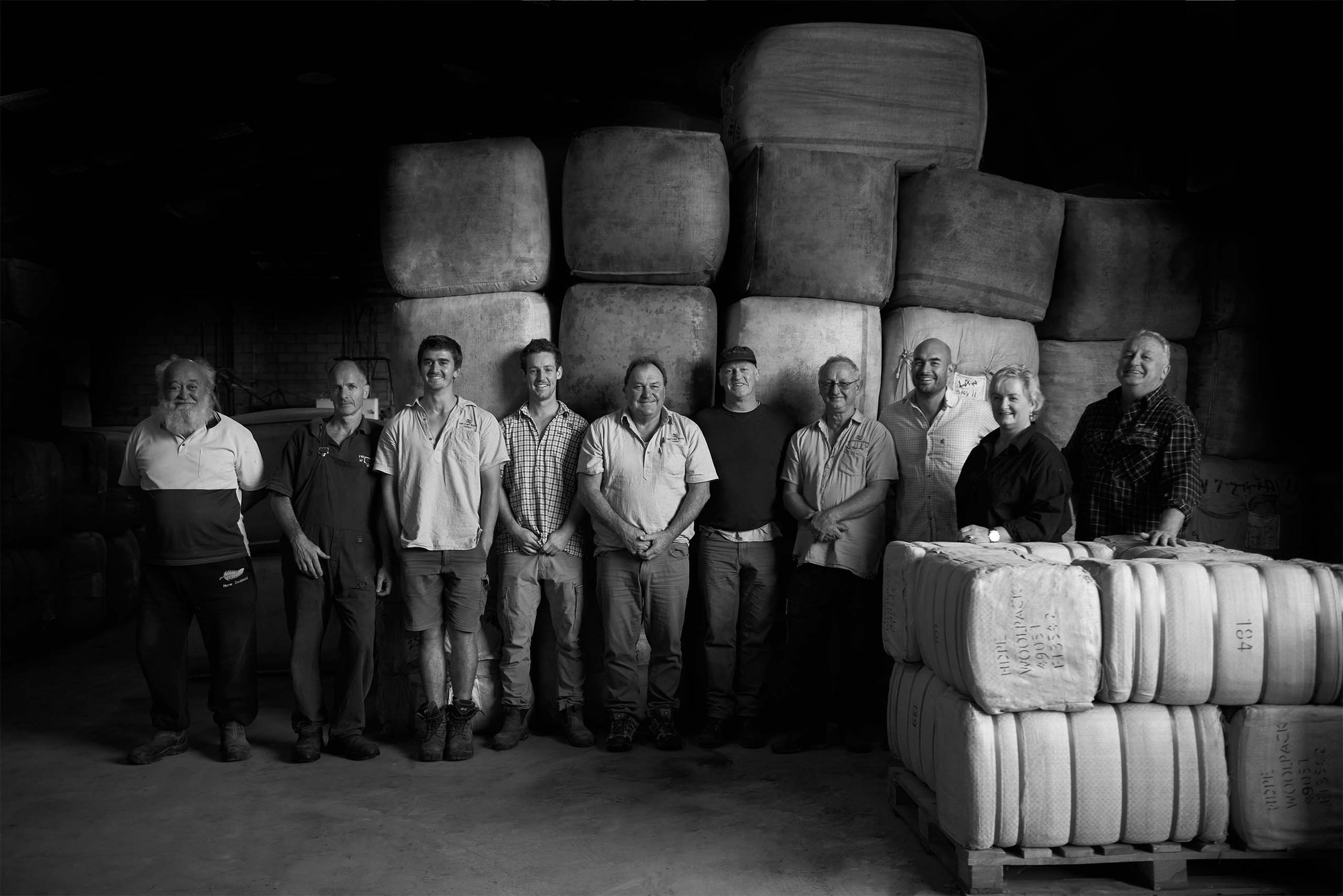 Wisewool Team at the Gisborne factory surrounded by raw wool bales.