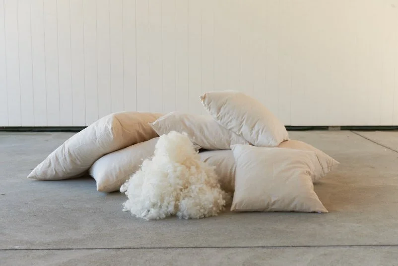 Stack of pillows filled with Wisewool™'s Wisefill™, a natural strong wool filling.