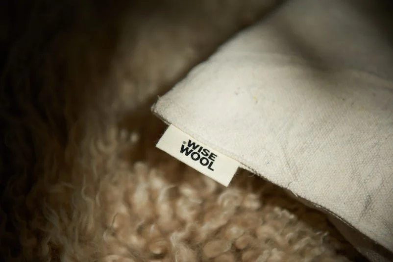 Wisewool™ pillow filled with Wisefill™ showing the product tag stitched into the seam.