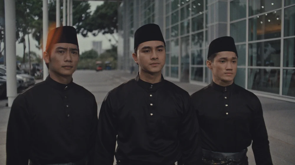 Three men dressed in black, from Ragging