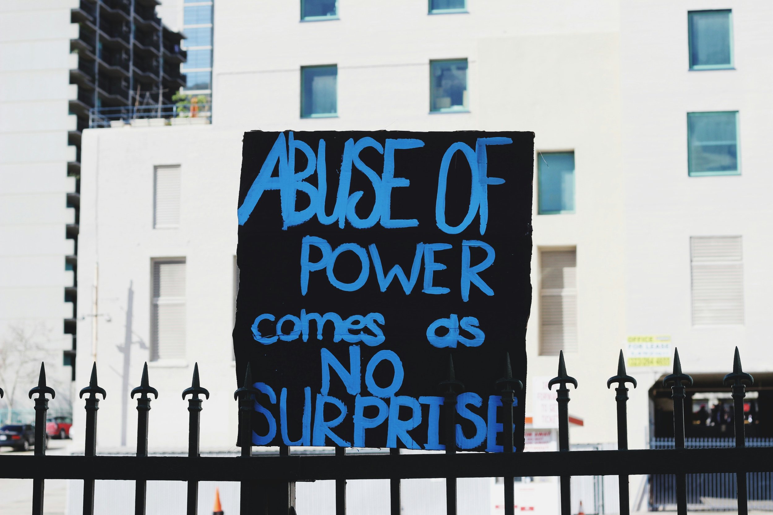 A sign proclaims - abuse of power comes as no surprise