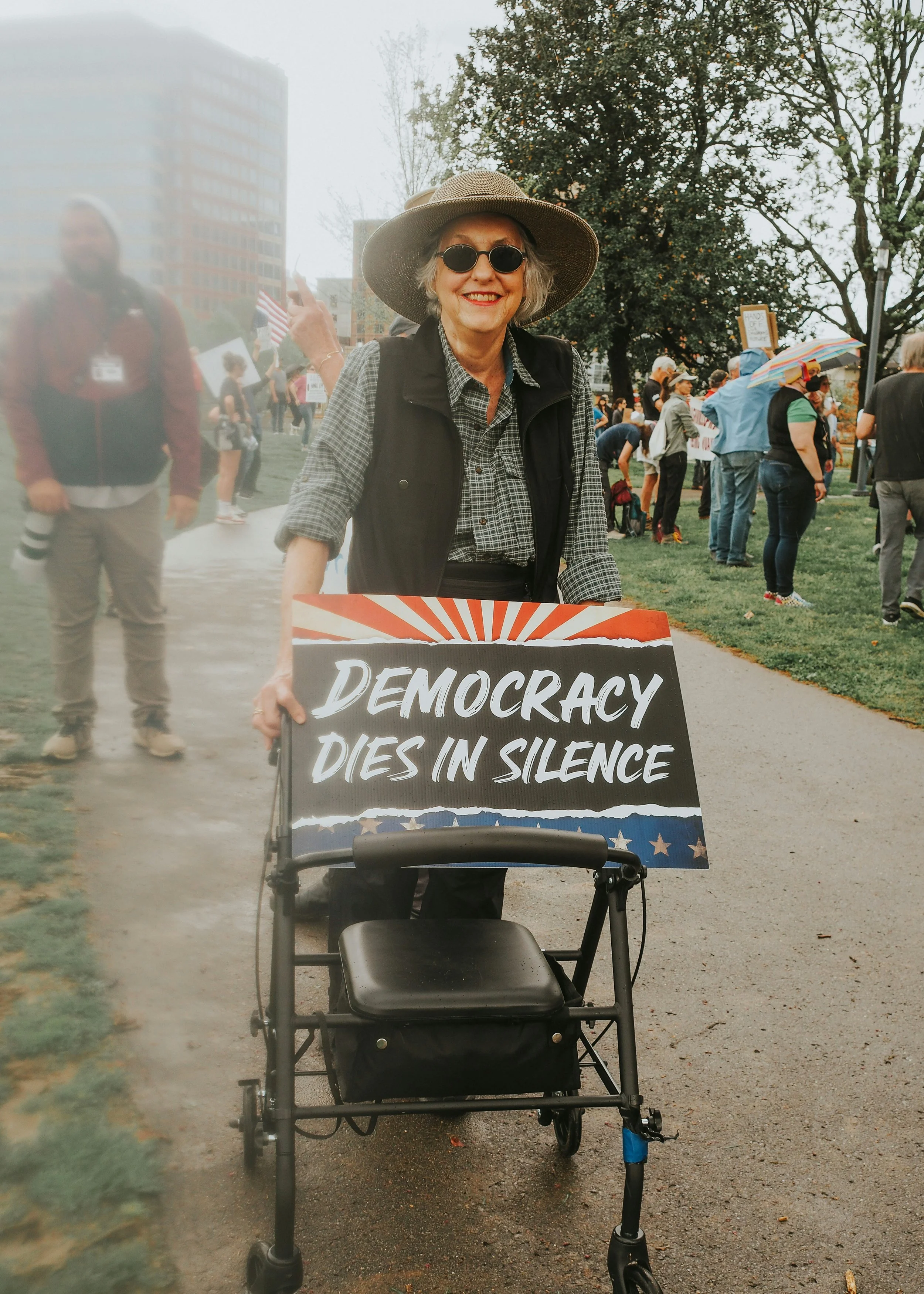 A woman at a protest with the slogan Democracy dies in silence.