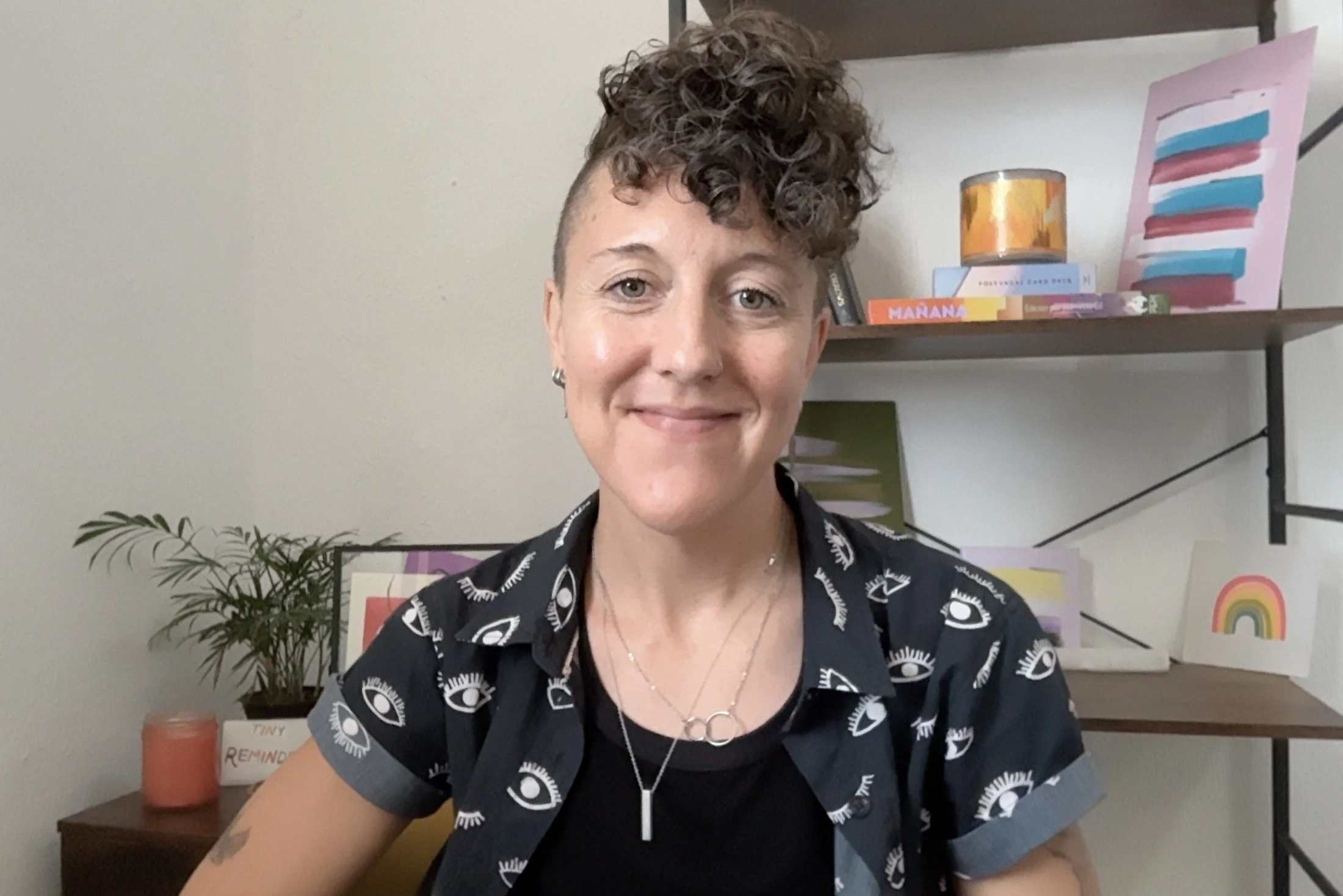 A photo of Eula Lys Dunkin, a trans nonbinary IFS and somatic therapist, in their virtual office