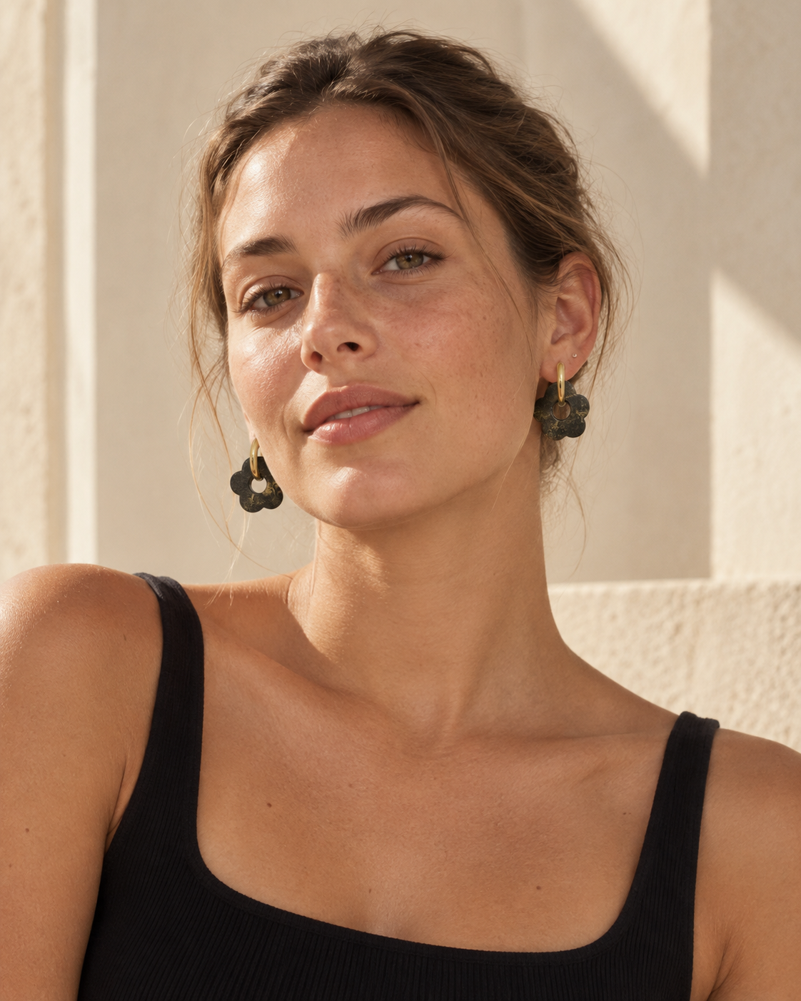 Model wearing Liberica coffee-stone flower hoop earrings with 18K gold-plated hoops, styled with a black top in warm natural light.