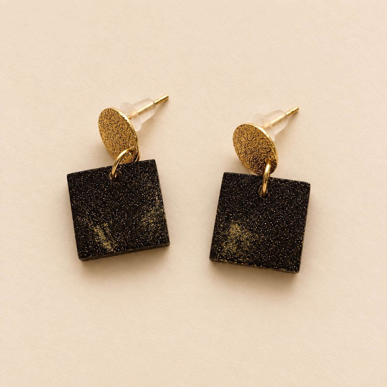 Close-up of Marie earrings showing square coffee-stone drops with real gold powder and textured 18K gold-plated findings.