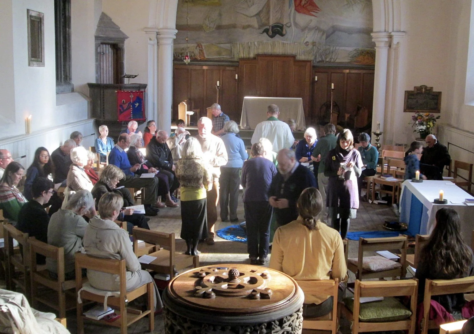 People receiving communion; chairs arranged in circle..