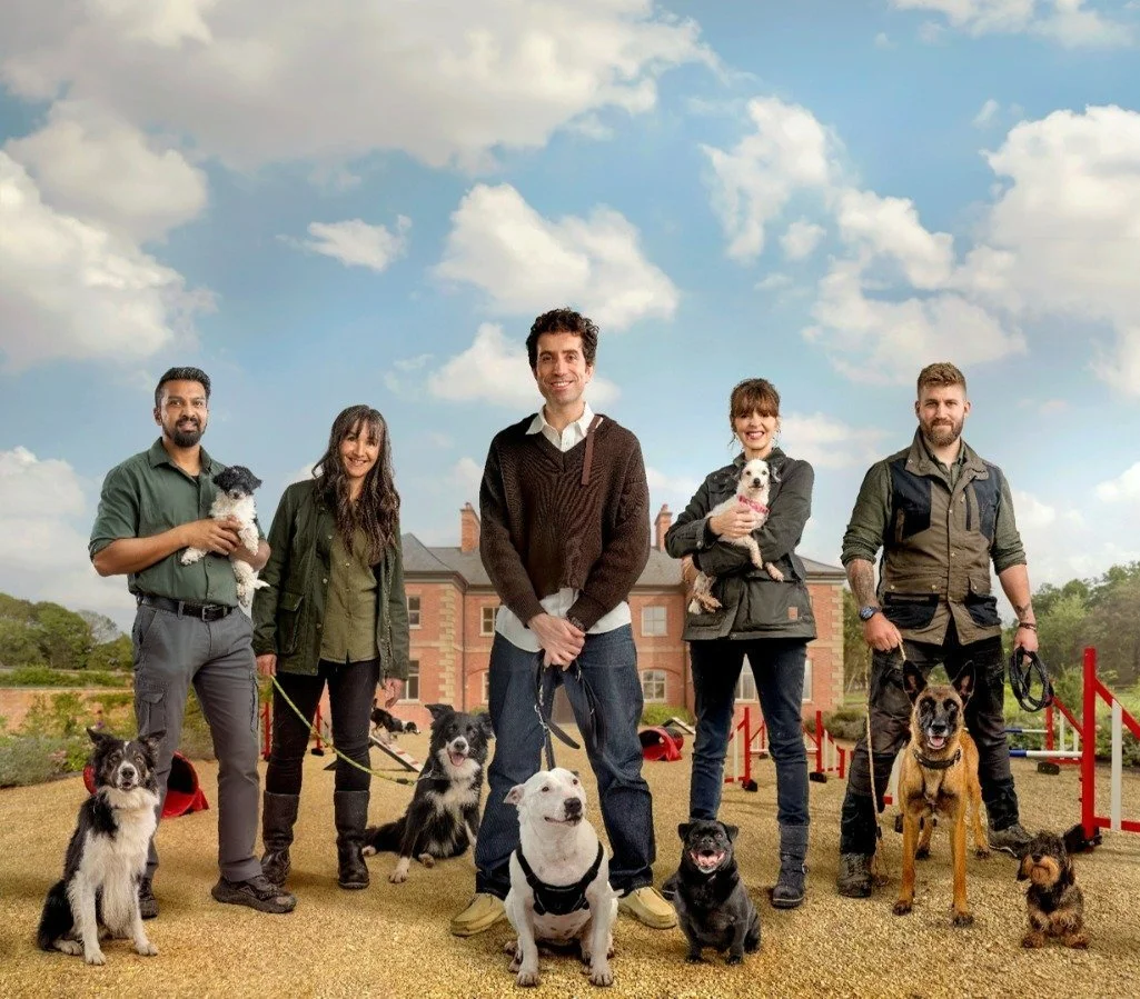 Group of five people standing outdoors with their dogs on a sunny day, in front of a large house .Offering Dog Daycare, Walking, Grooming, Hydrothherapy, Fun Swims , Field Hire , Puppy Classes, Agility & Hoopers, Skills Classes, Mantrailing, Training
