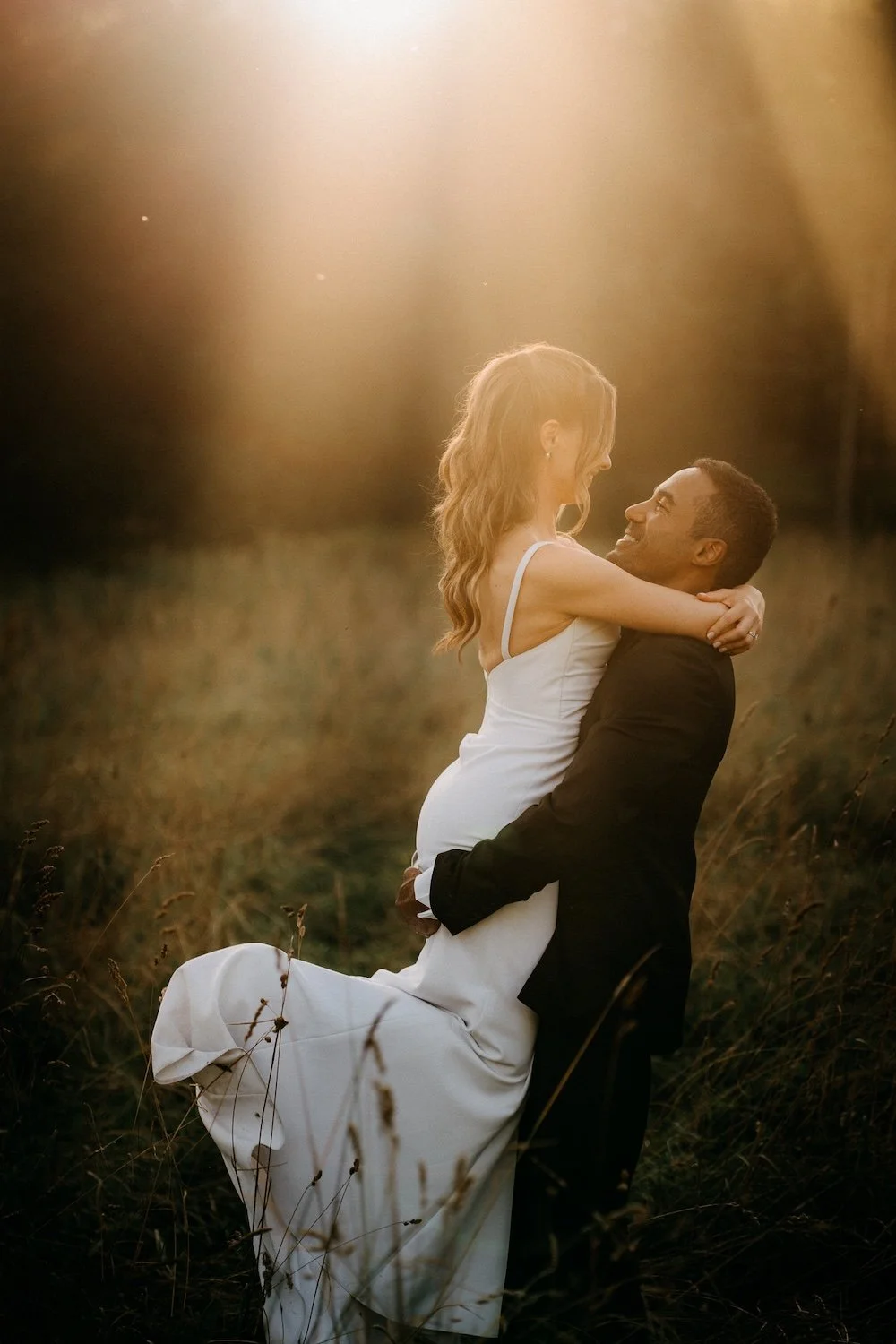 Pariskunta halaa toisiaan luonnon keskellä auringonlaskun aikaan.