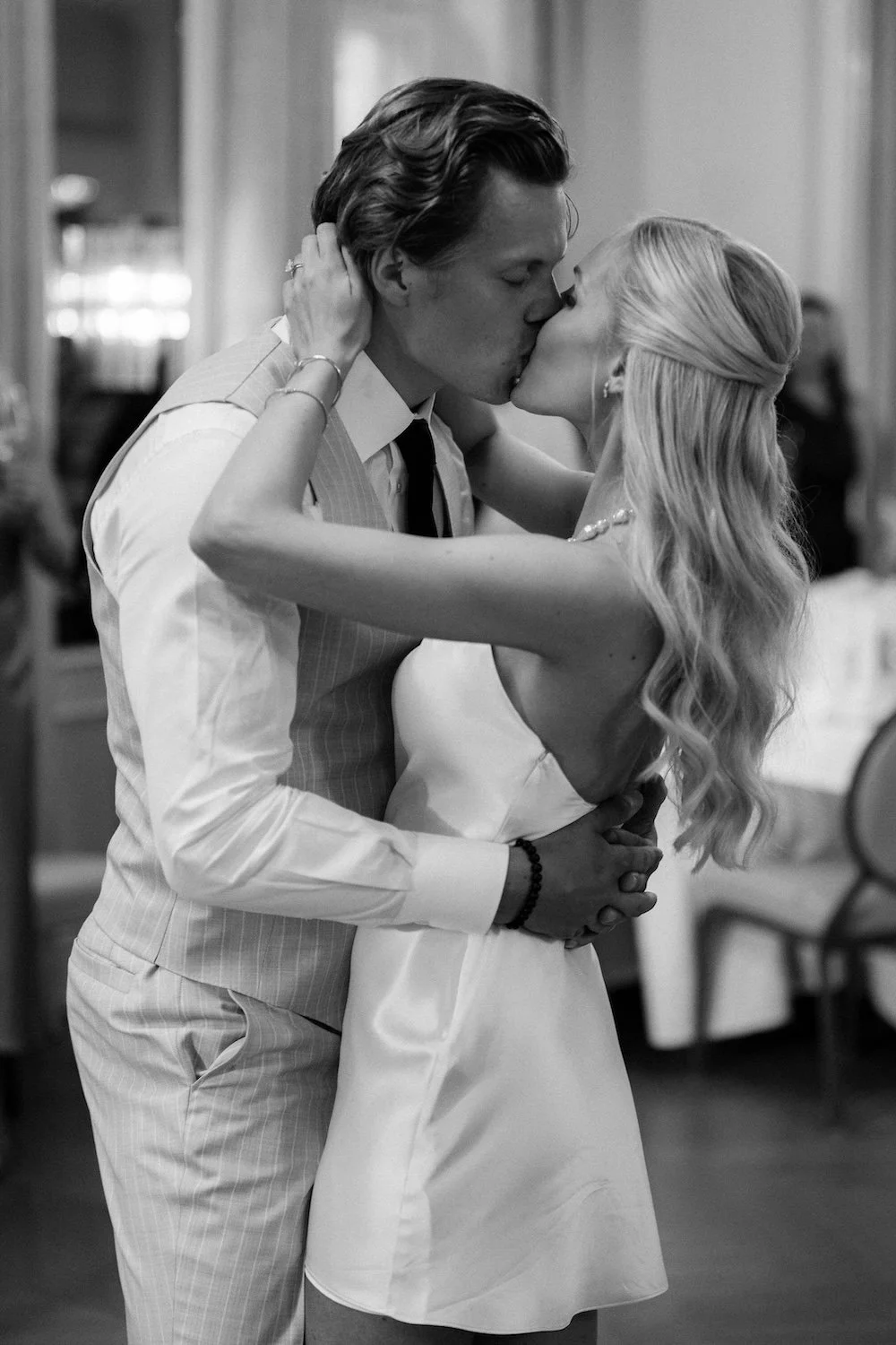 Kuvassa kaksi nuorta ihmistä suutelemassa ja halaamassa toisiaan. Taustalla tilaisuus, mahdollisesti häät.