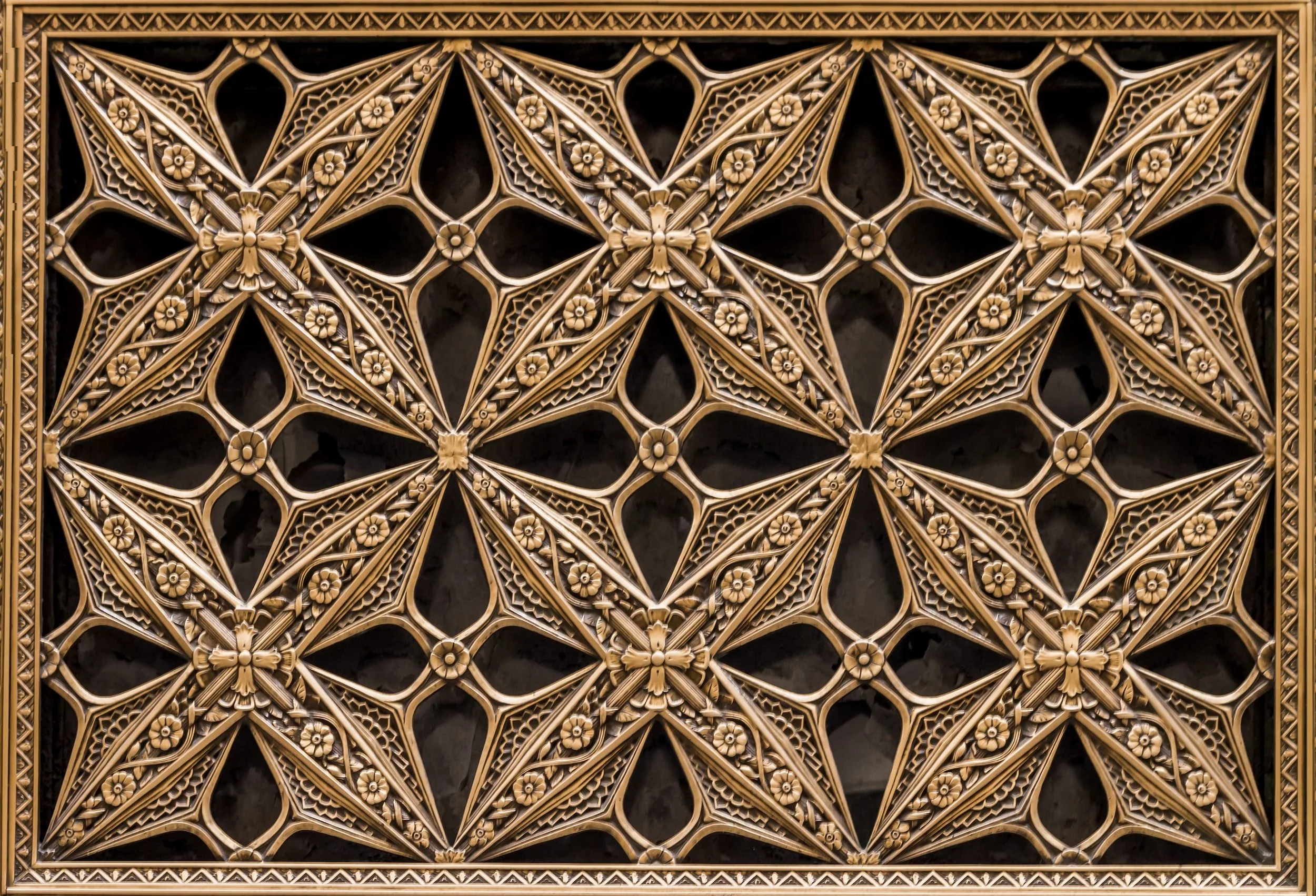 Ornate gold-colored decorative panel with geometric patterns and floral motifs.