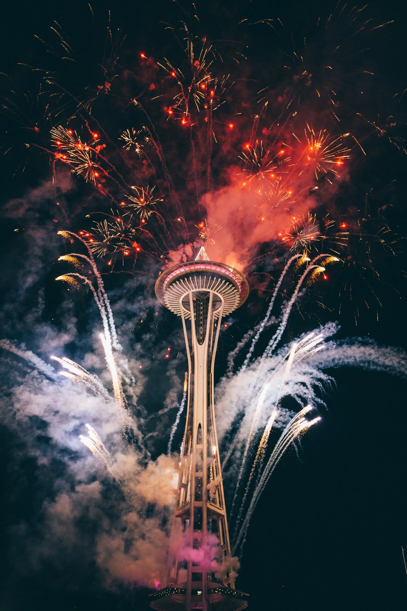 Fireworks exploding around the Space Needle during a nighttime celebration in Seattle.