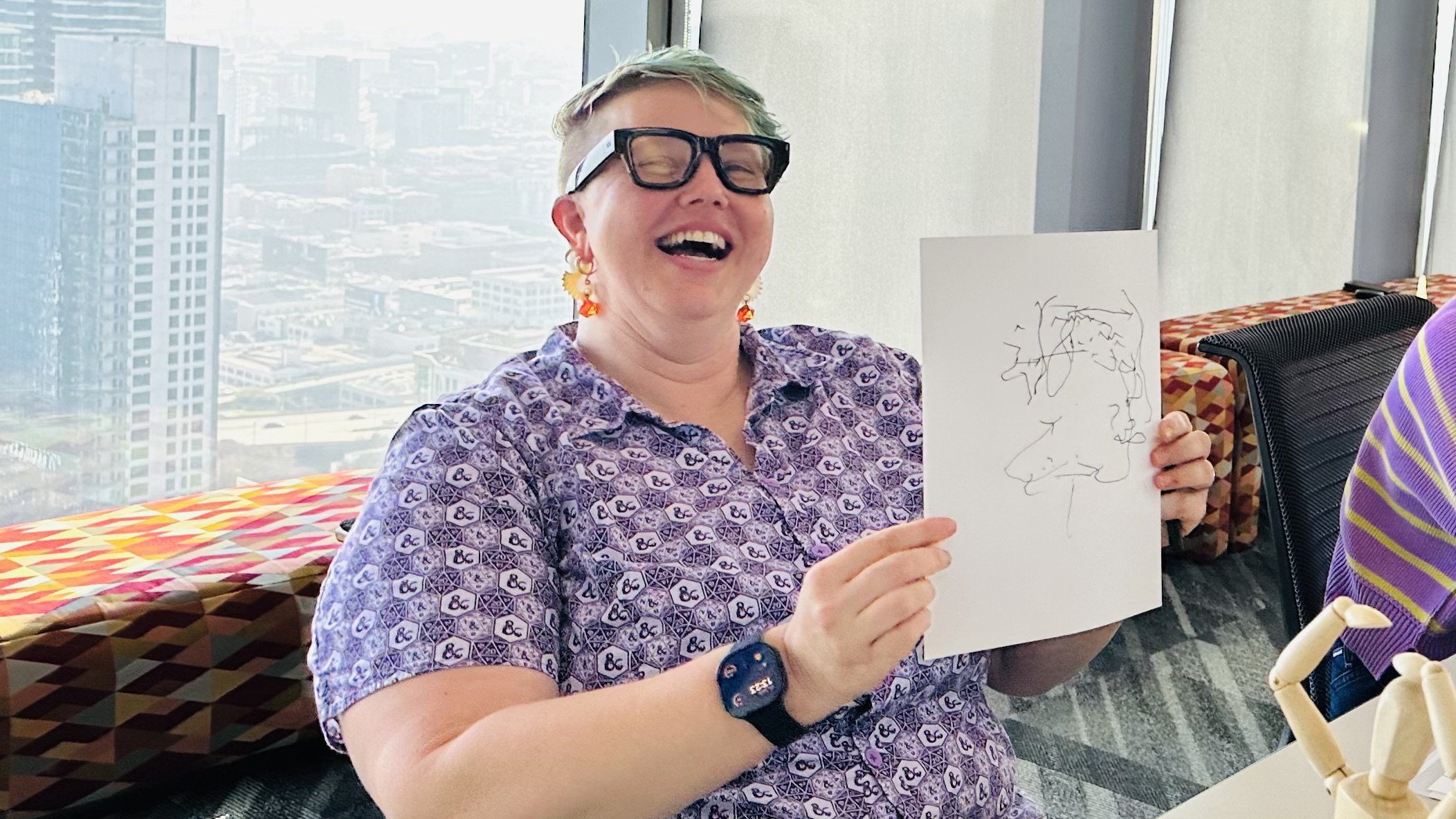 Happy Participants laughing during drawing partner portraits without looking at page during a Make Believe Works team building workshop