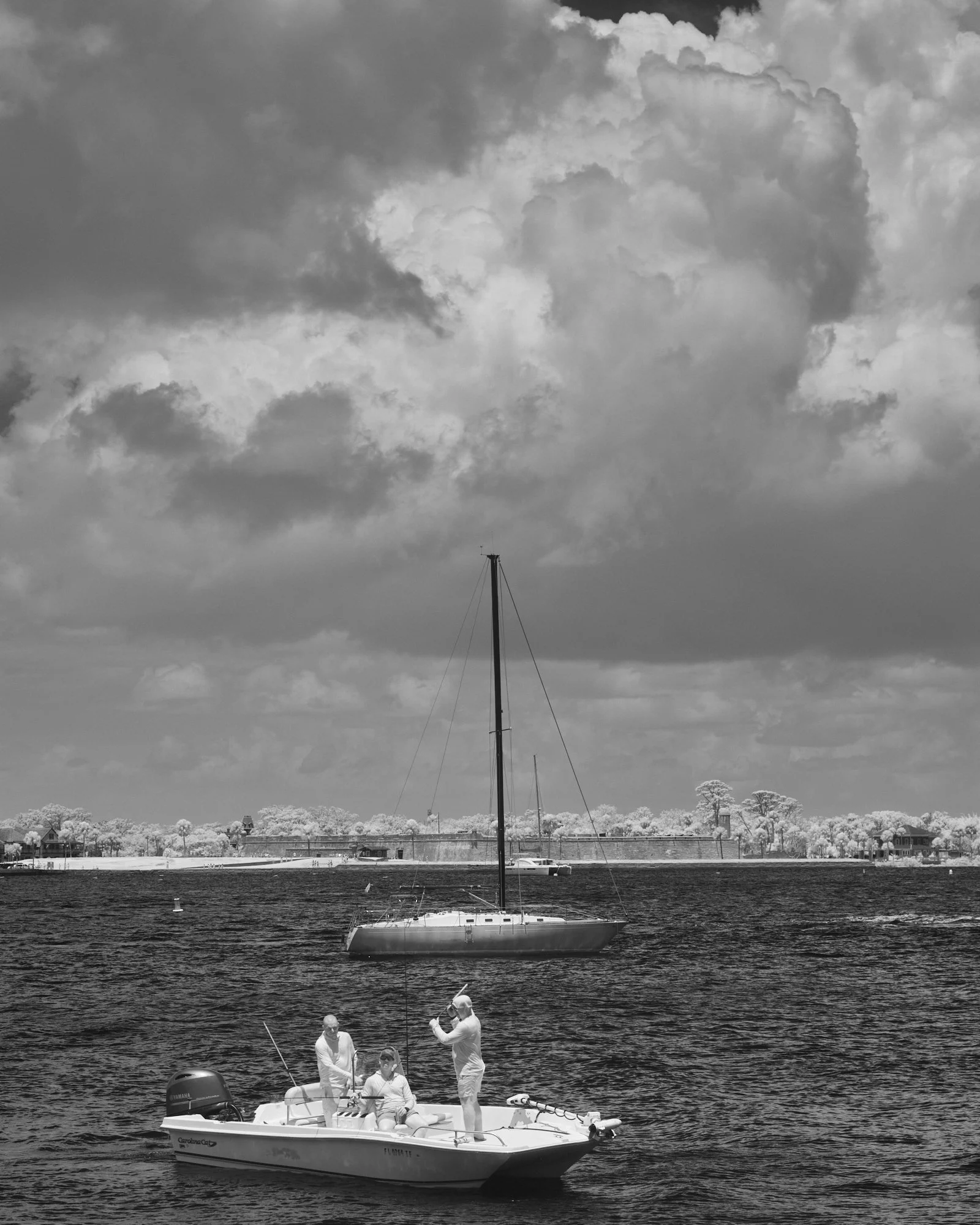 Boats against the infinite sky in middle ground with fishermen in the foreground and Castillo in the distance. St Augustine downtown. looking outward into the void