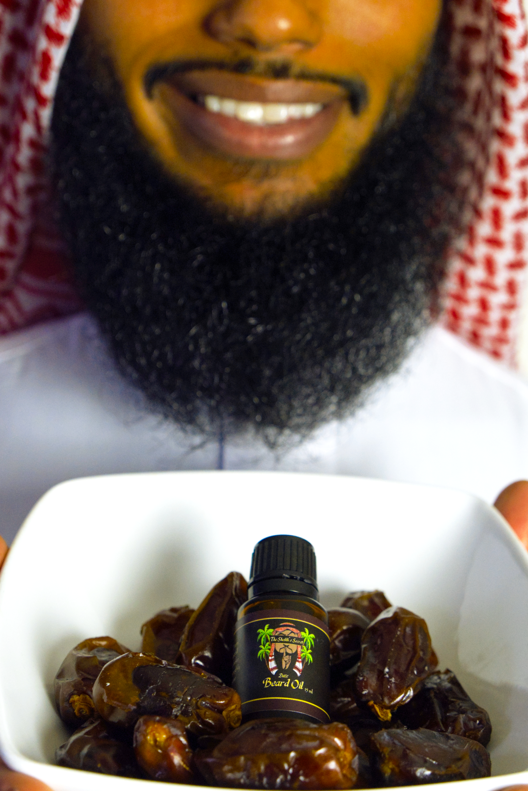 Sheikh holding bowl of dates with beard oil in center has an amazing beard
