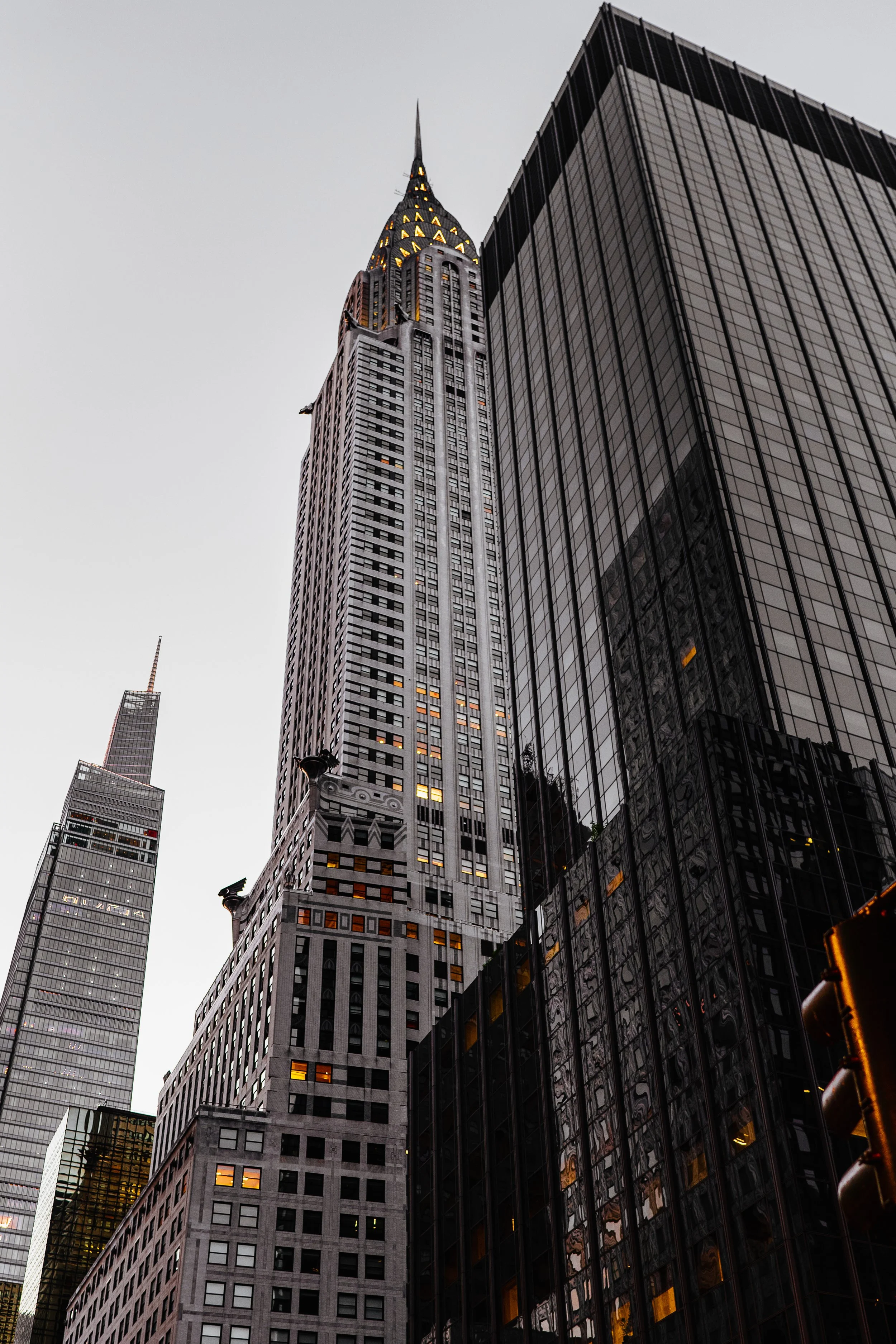 Skyscrapers in New York City, featuring the Chrysler Building and surrounding high-rise architecture, with a clear sky backdrop.