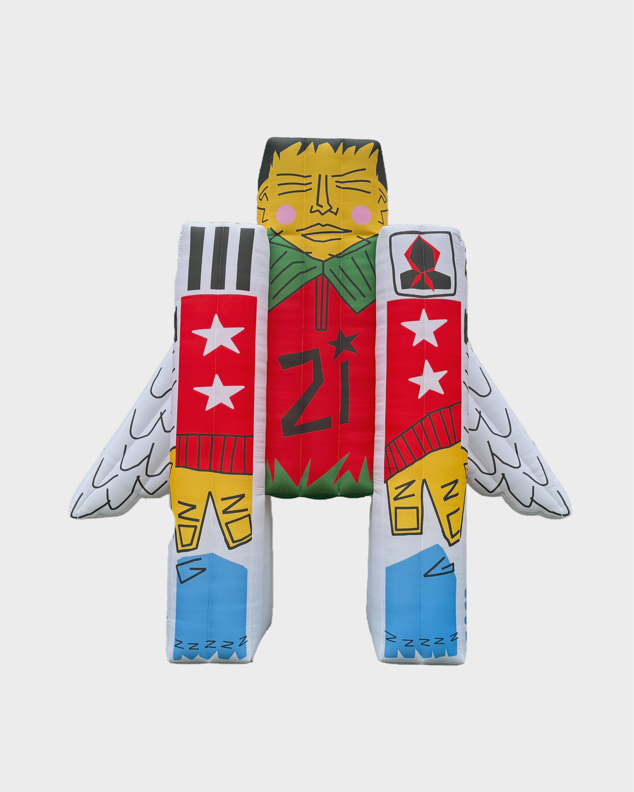 Colorful inflatable figure resembling a person with a yellow face, black hair, pink cheeks, and closed eyes, dressed in red, green, blue, and white clothing with star and geometric patterns, set against a gray background.
