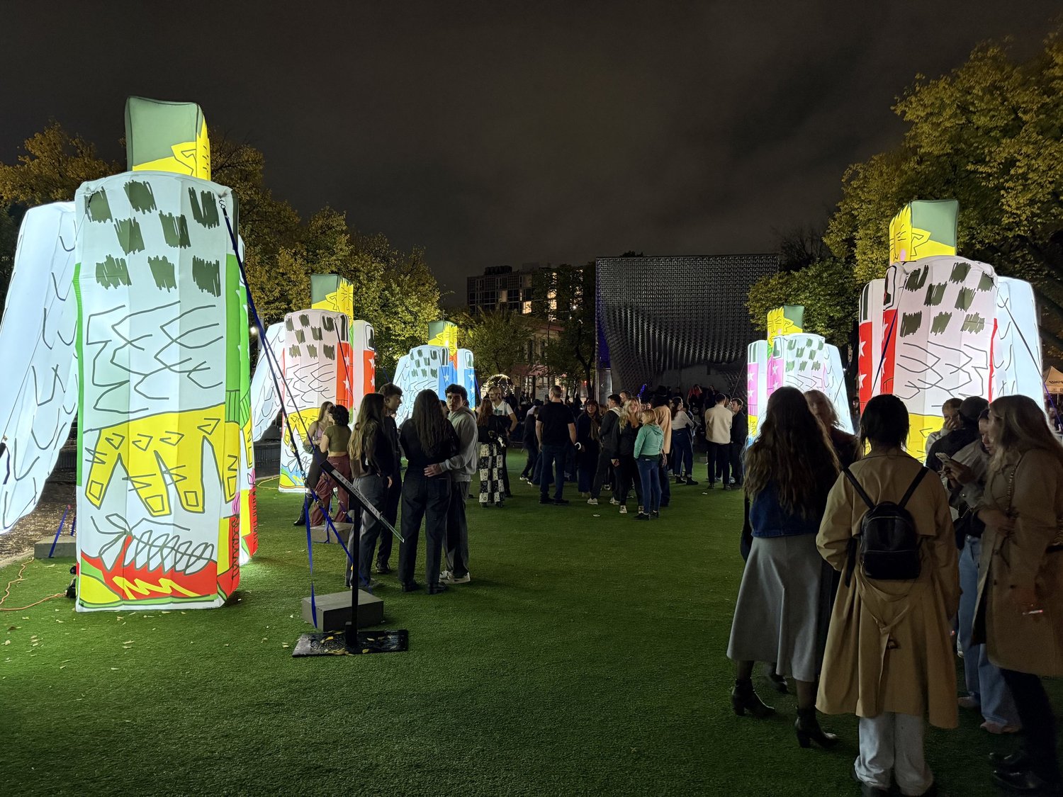 Illuminated IMABOX sculptures with visitors at night