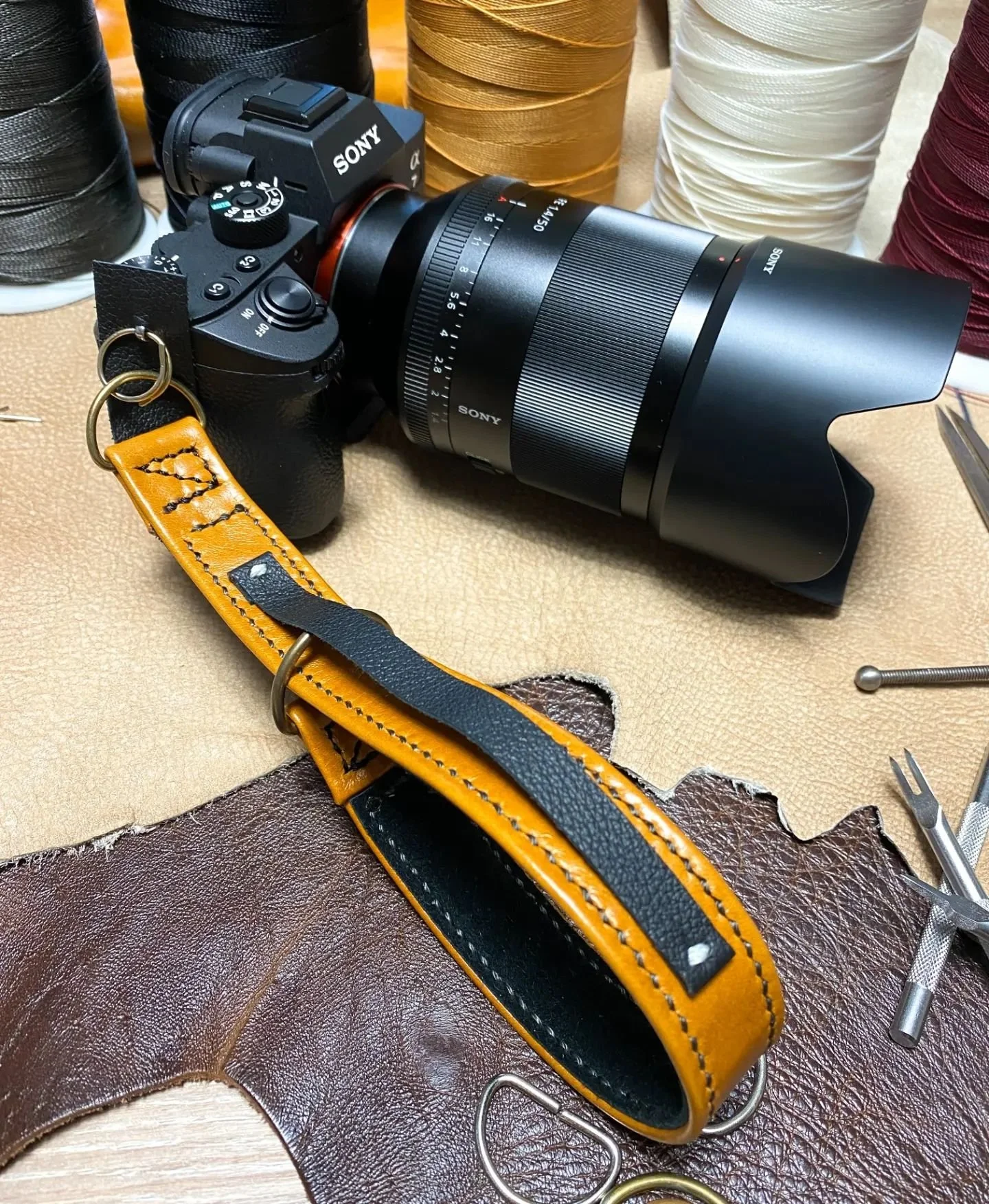 Something completely different...

While we don't currently offer camera straps as a standard product, we have made them upon request in the past, with standard 'd-ring' and Peak Design type attachment.
We are going to offer photography focused produ