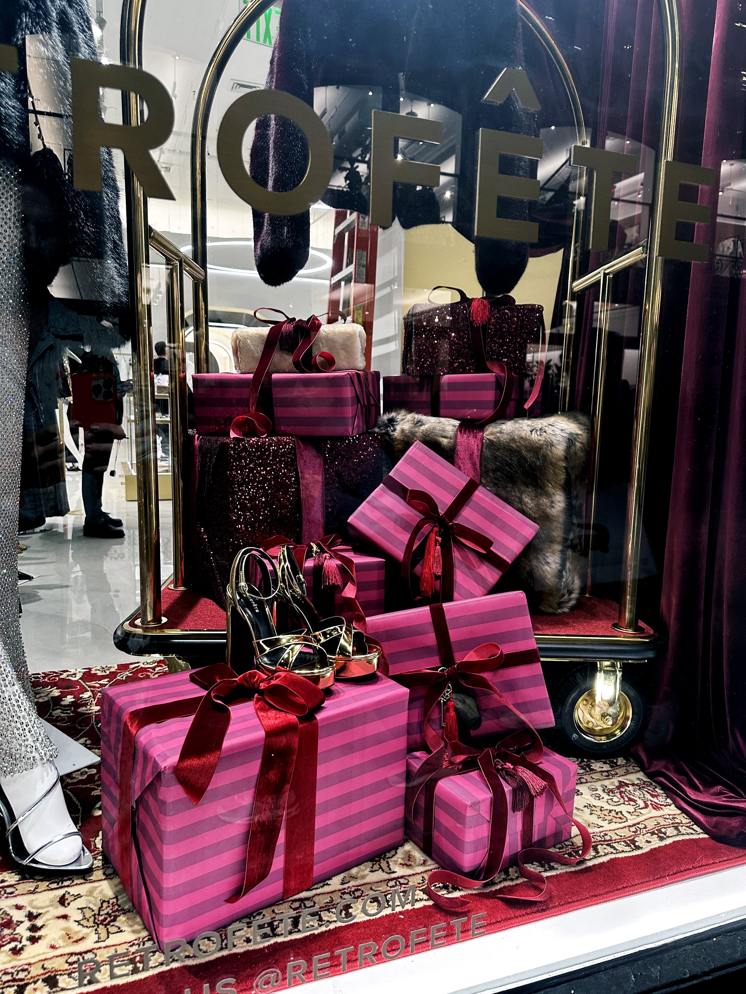 Wrapped Gifts - Pink and Burgundy RetroFête Soho on Spring Street in New York City.  Holiday Retail Windows 2025
