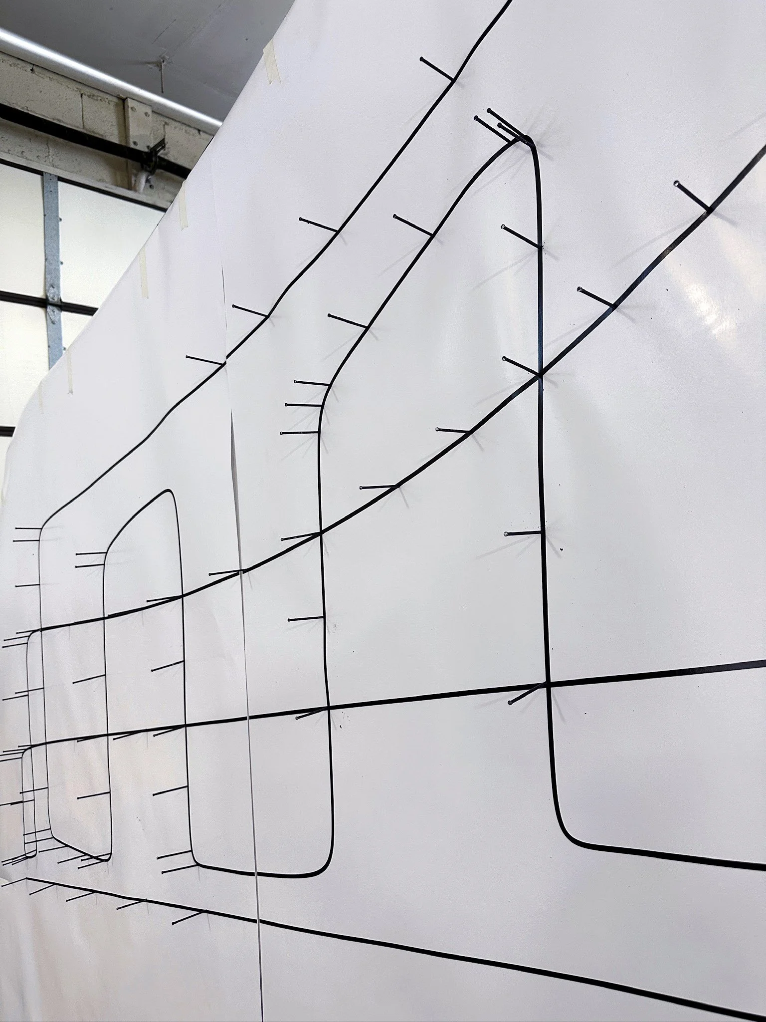 Using the line art as a guide for nail placement. Ensuring the nails are all equally spaced and in the same depth.