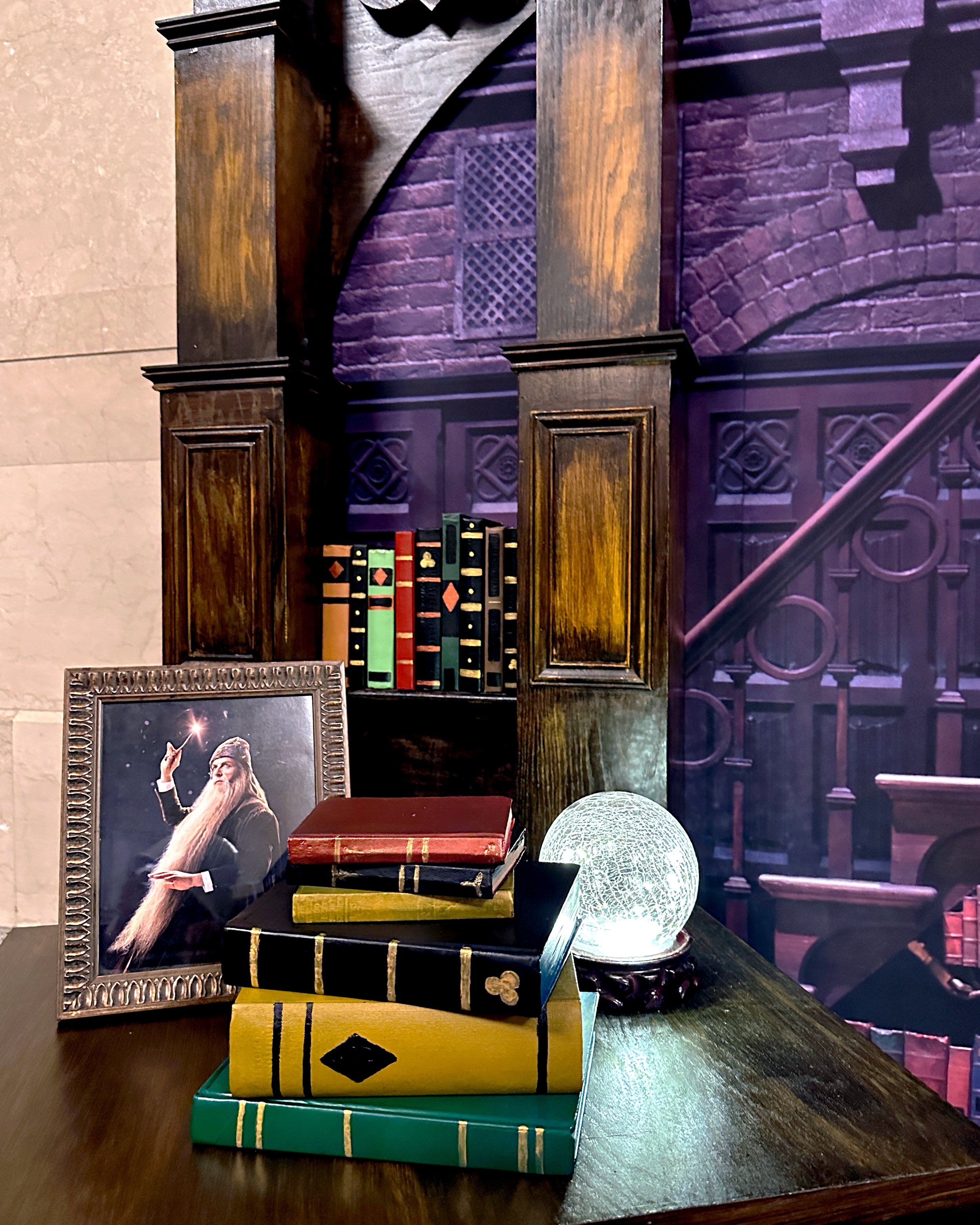 Details from the "Harry Potter and The Cursed Child" photo booth in Grand Central, including handmade wood structure and hand painted school books.
