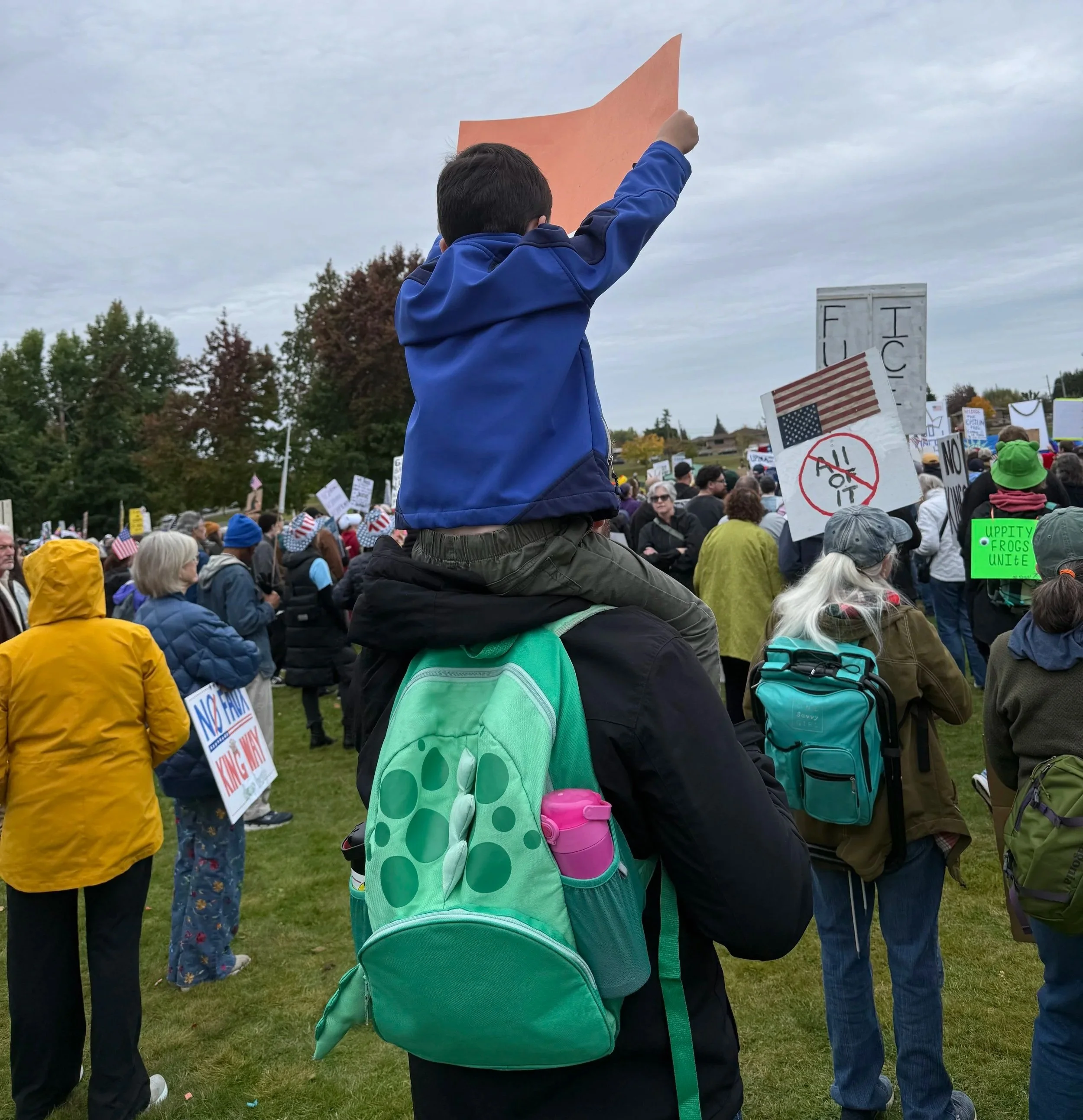 My son on my shoulders with a sign