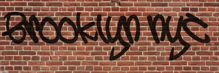 Black graffiti spelling 'Brooklyn NYC' on a red brick wall.