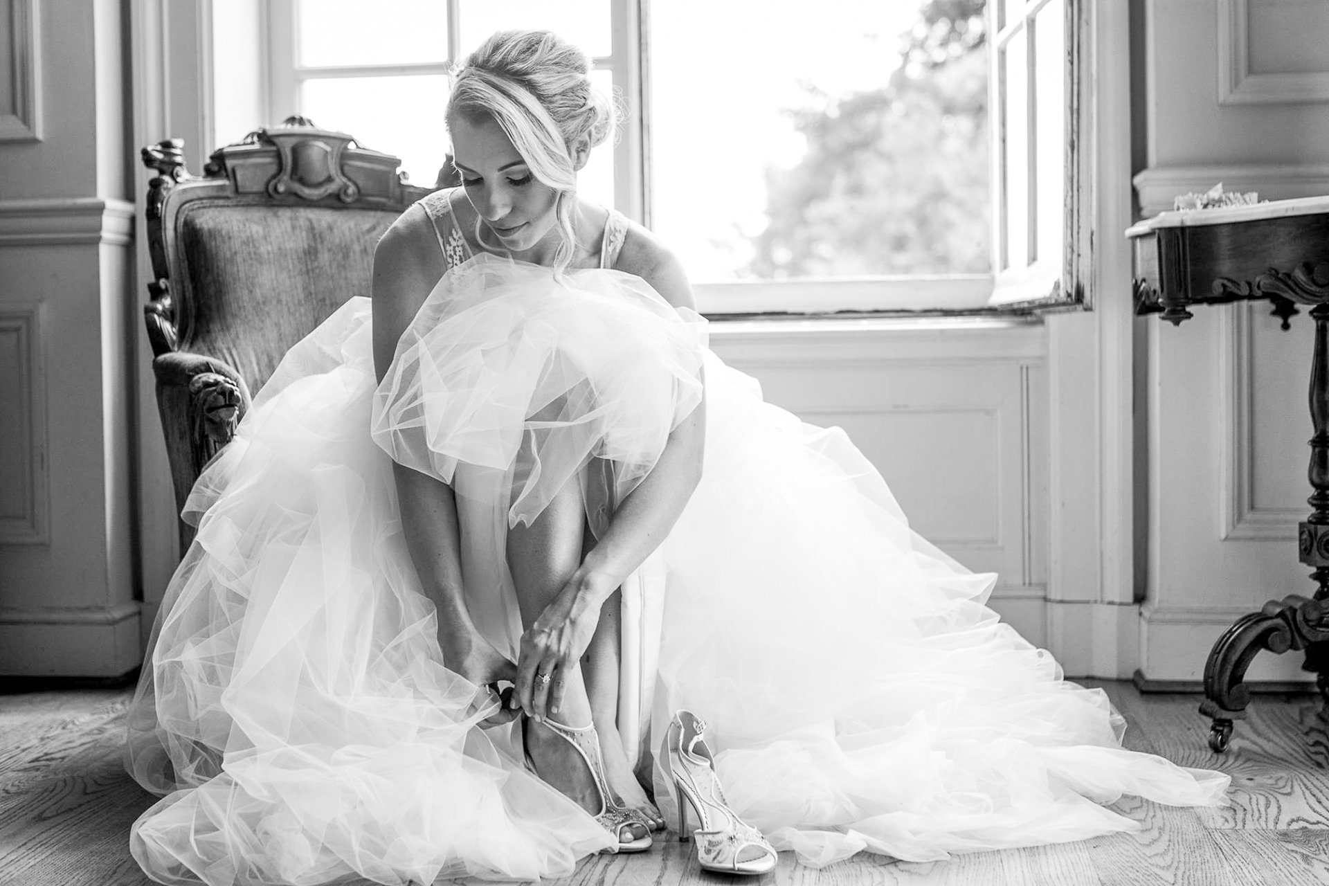 Bride in Black and white putting on shoes