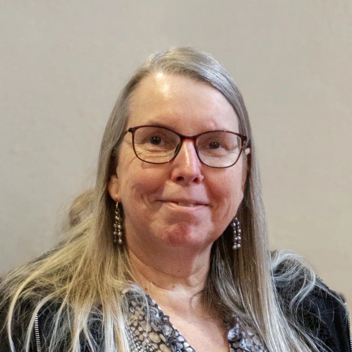 Melanie Bailey, Assistant Treasurer, lady with glasses and long hair with earrings