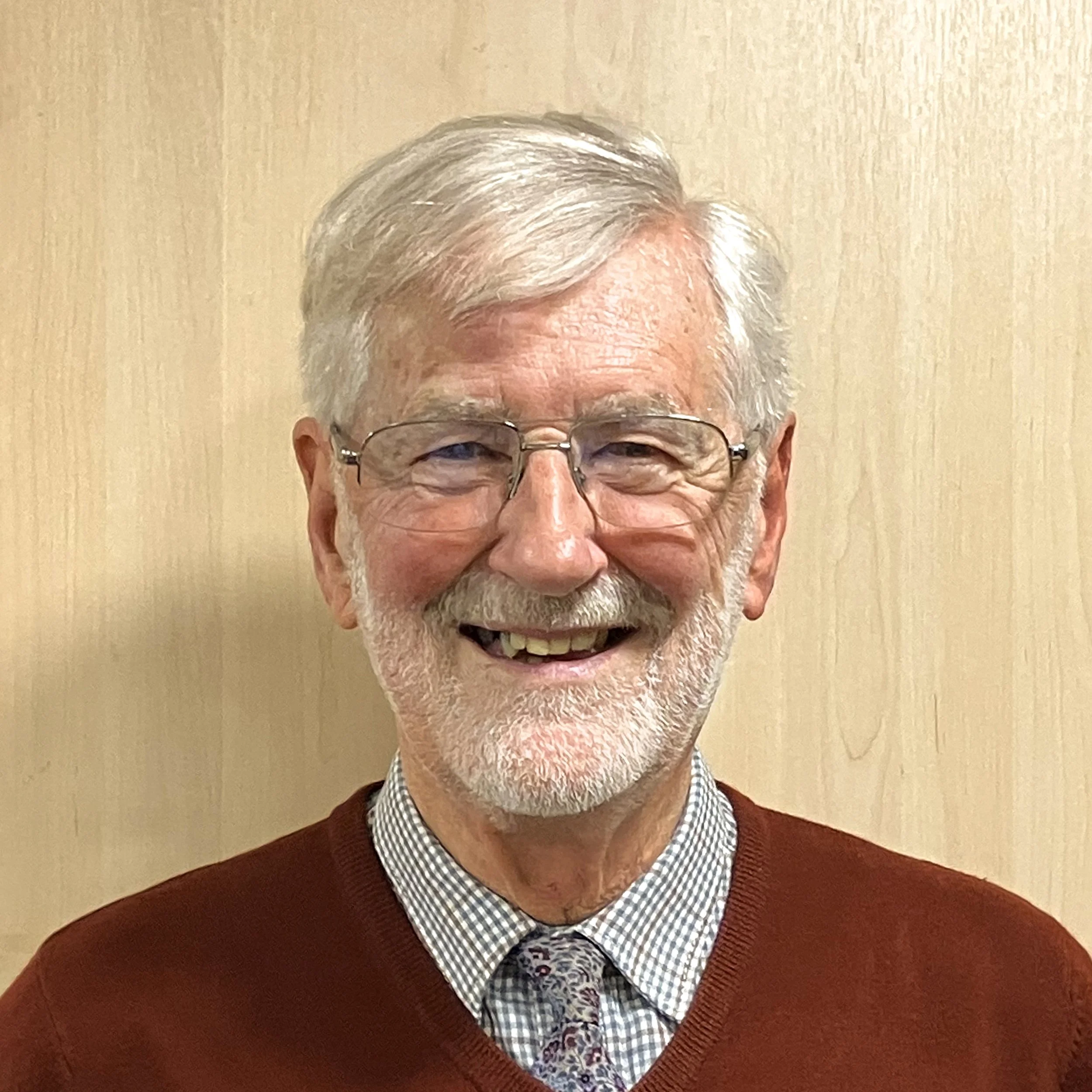 Nelson Pallister, House Group Leader, man wearing smart red jumper and tie with glasses, white hair and beard