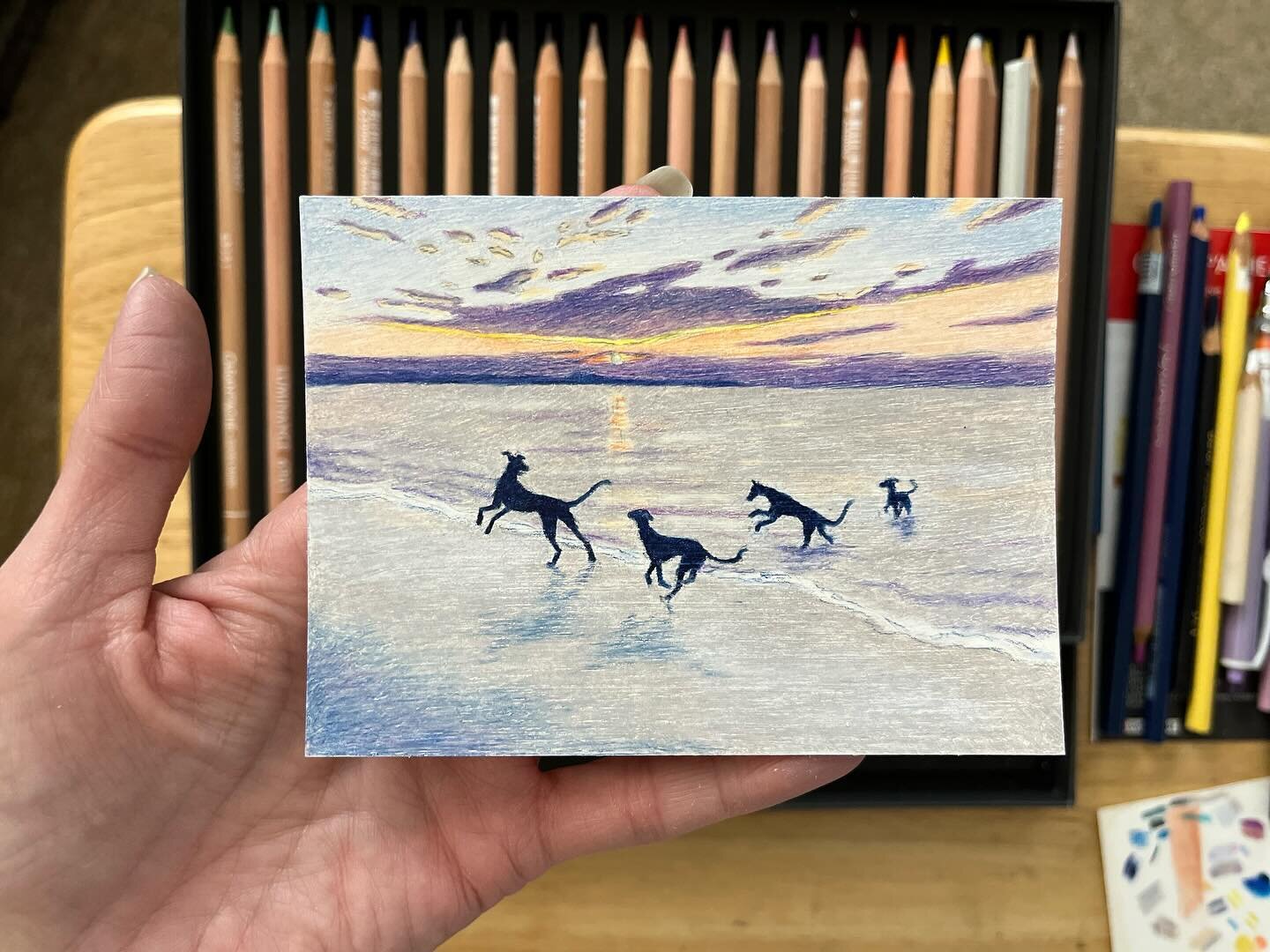 Beach dogs! A beautiful sunset and dogs at play! 🐾🧡🌅
This is a composition that I have done before, as a digital painting. I wanted to give it a go in colored pencil. 
I&rsquo;m not sure how I feel about it. It&rsquo;s okay. The colored pencils wi