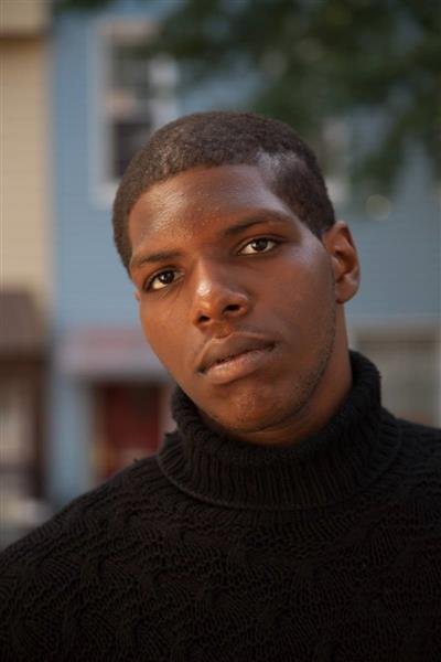 Man in a black turtleneck sweater standing outdoors.