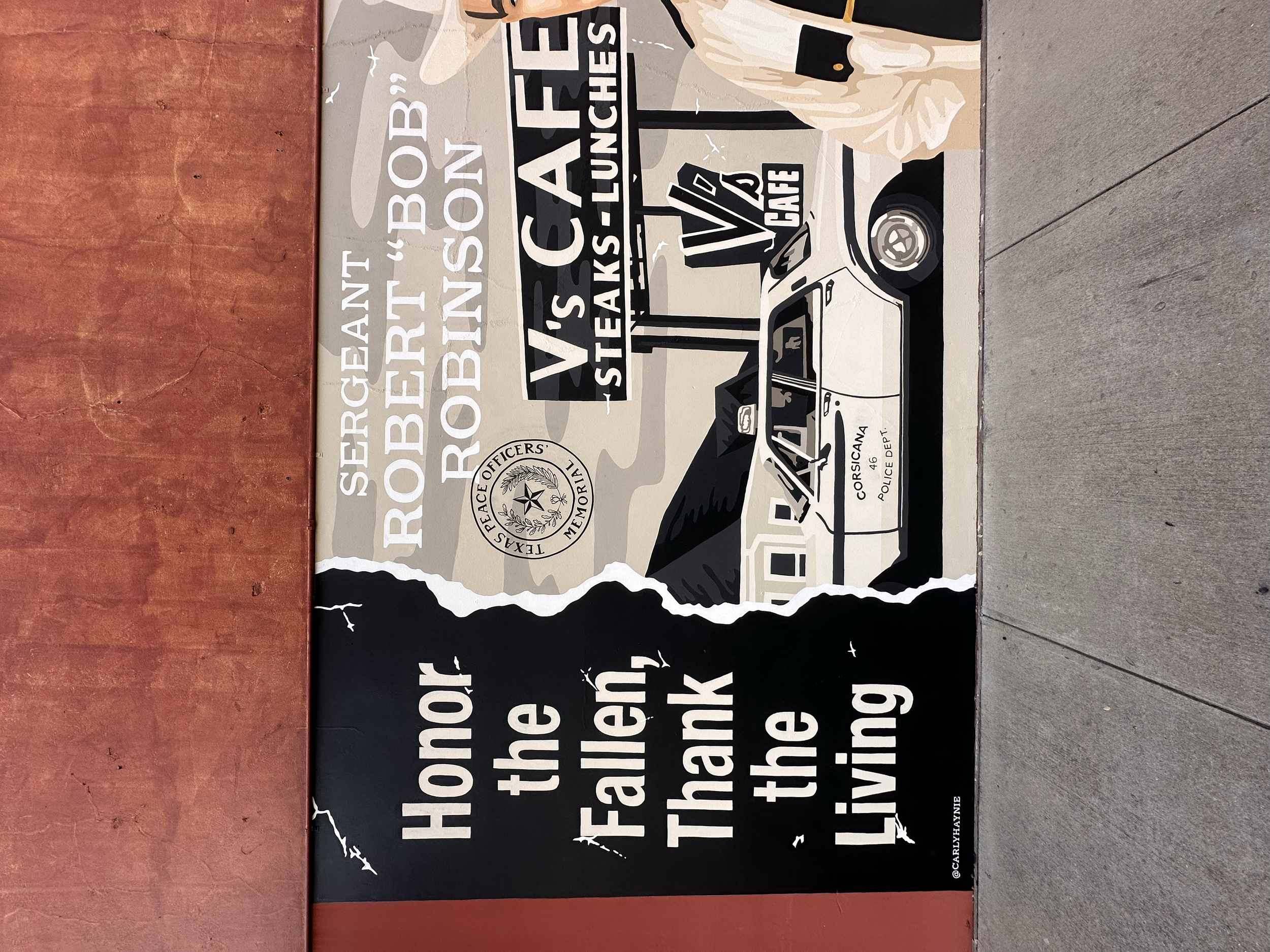 A mural commemorating Sgt. Robertson, a Texas peace officer. It features a police car, a badge, and a figure in uniform, with an inspirational quote: 'Honor the fallen. Thank the living.' The mural includes references to Texas peace officers and the 
