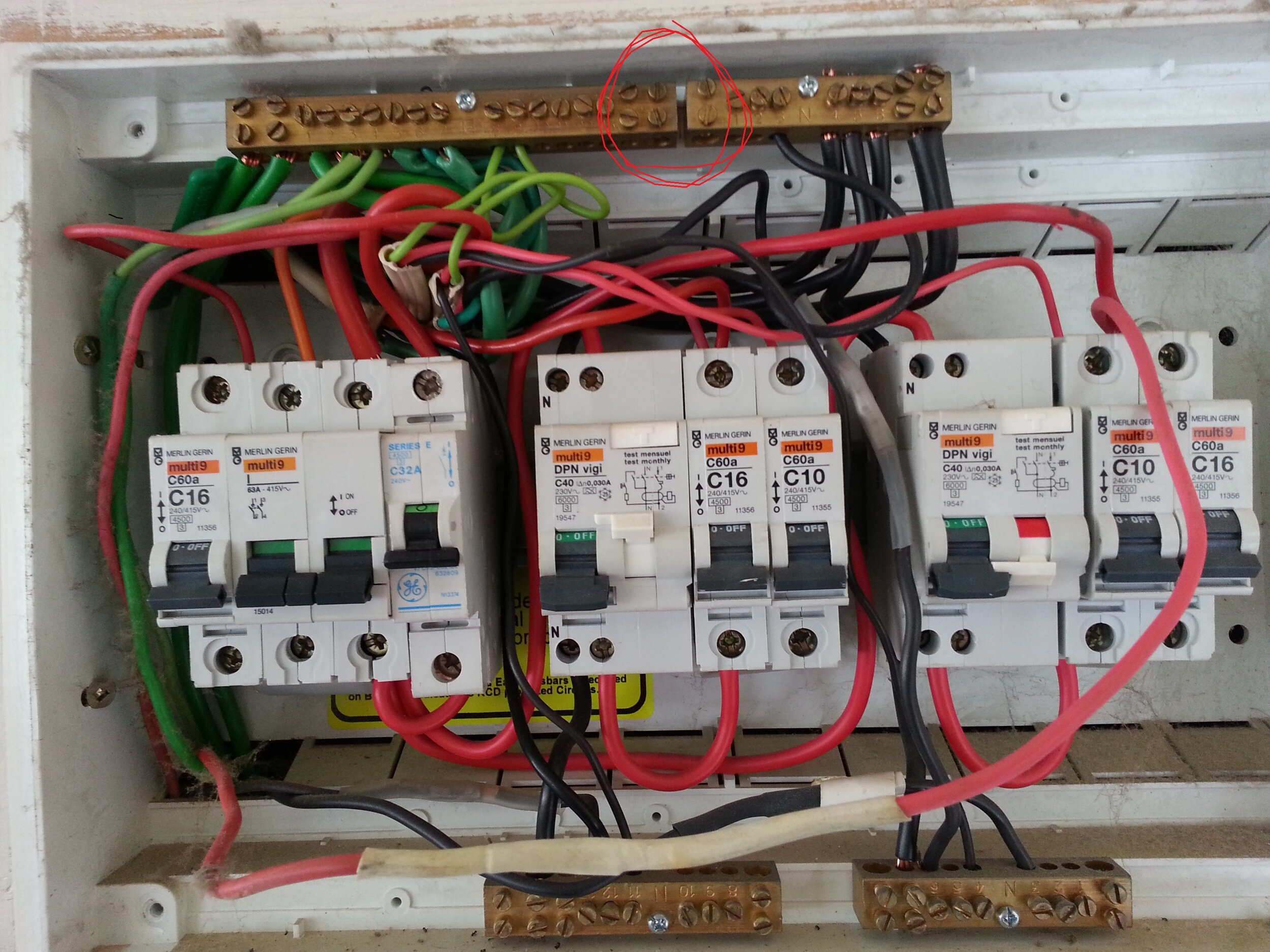 DIY switch board. Tenant complained of getting shocks off of the stove. Wiring too small and the MEN link left out of the Neutral & Earth bus. (Circled in red)