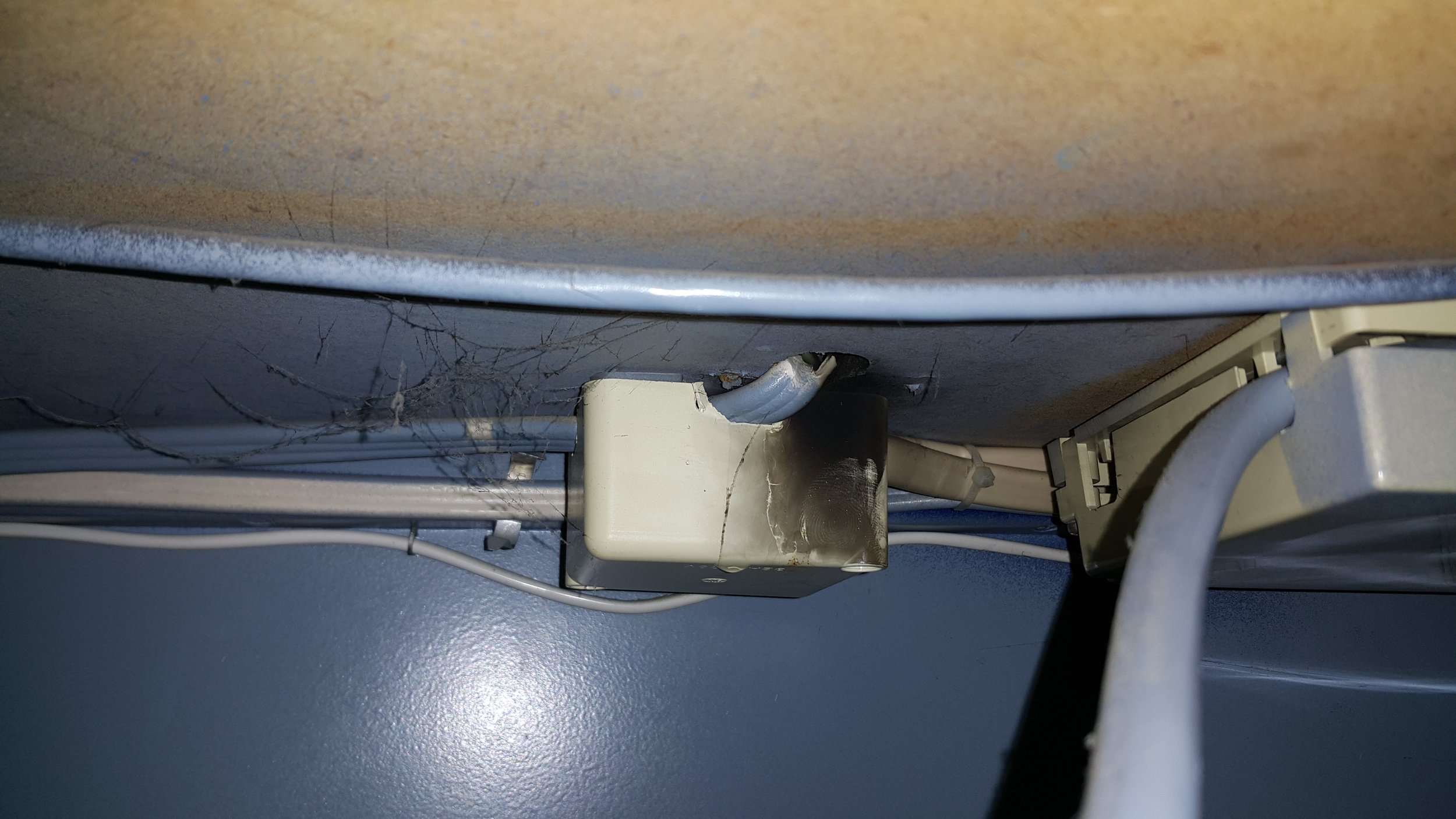 A junction box installed in the underside of a desk. Some knocked over a cup of coffee and flooded the junction box shorting out the power circuits inside.