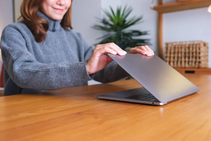 Woman closing her laptop at the end of the workday