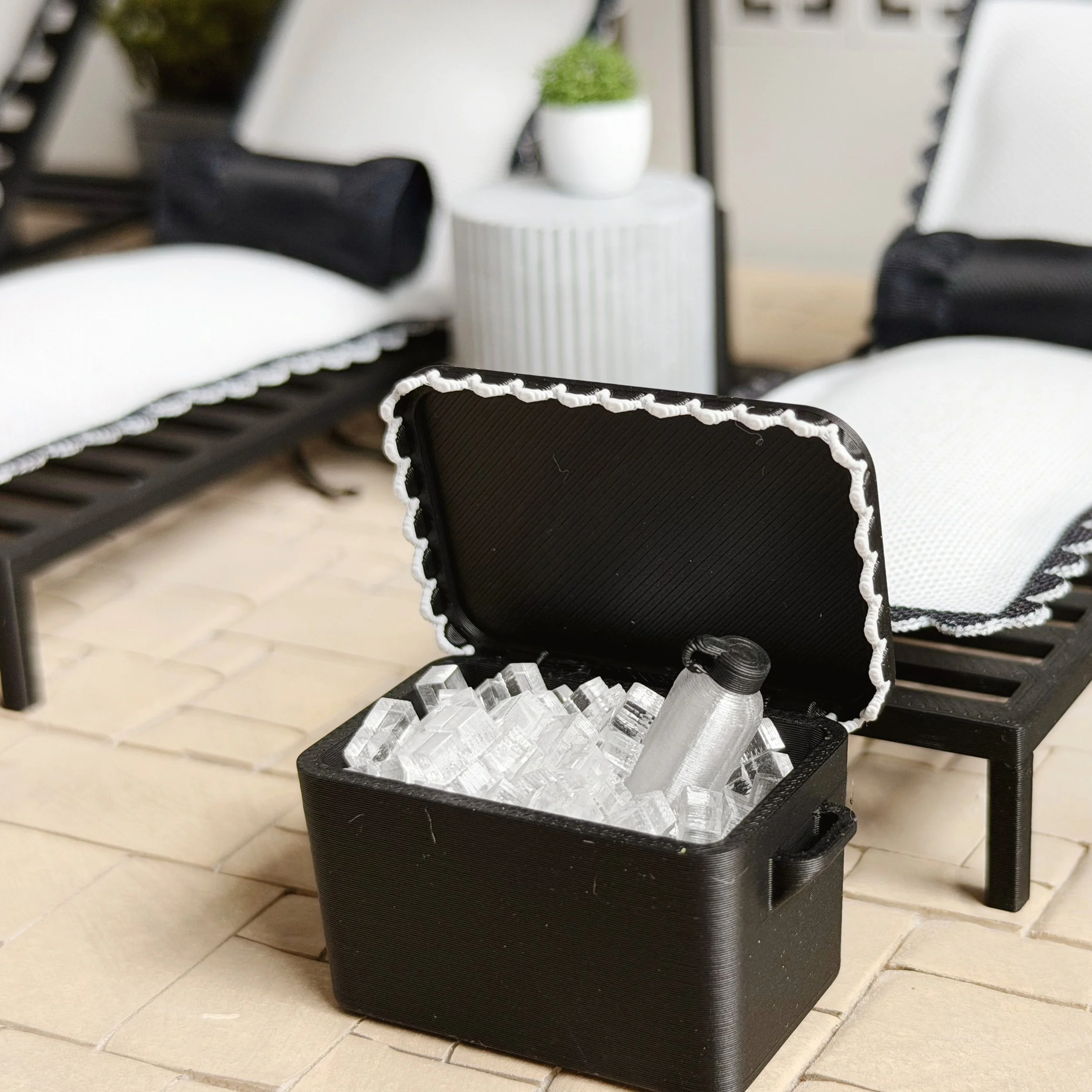 Black miniature cooler with lid slightly open, showing depth and scale