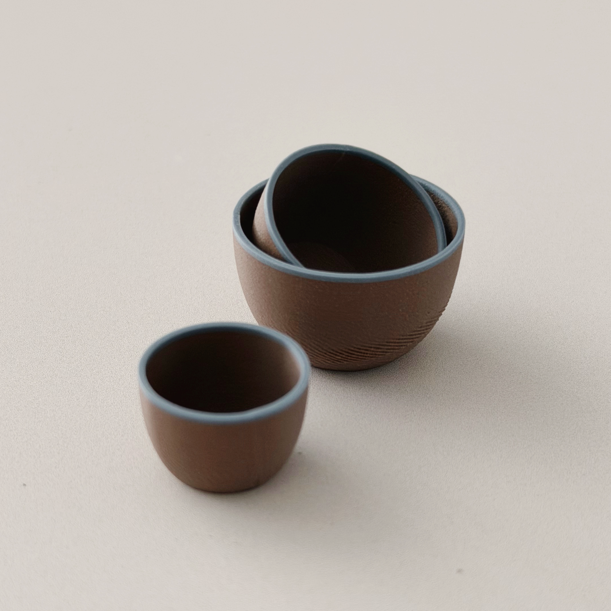 Miniature brown and blue nesting bowls stacked for a dollhouse kitchen