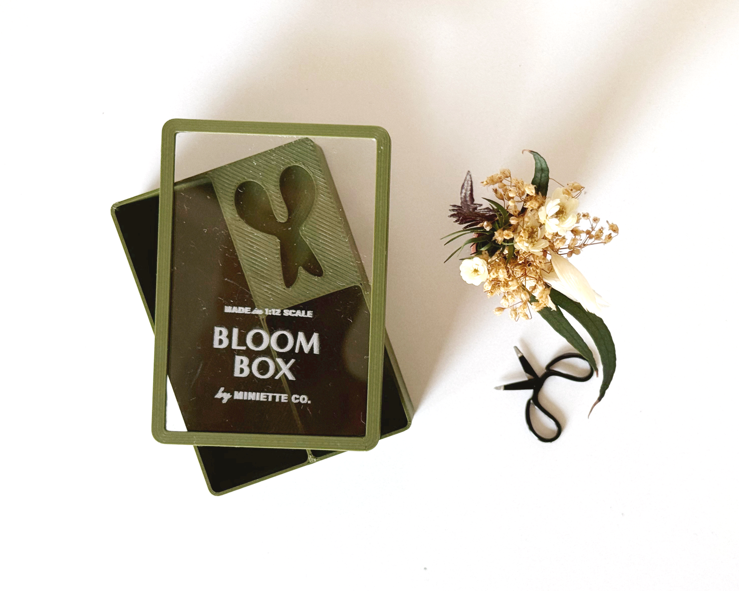 Miniature fall Bloom Box with tiny preserved florals, moss green vase, and working scissors in 1:12 scale.