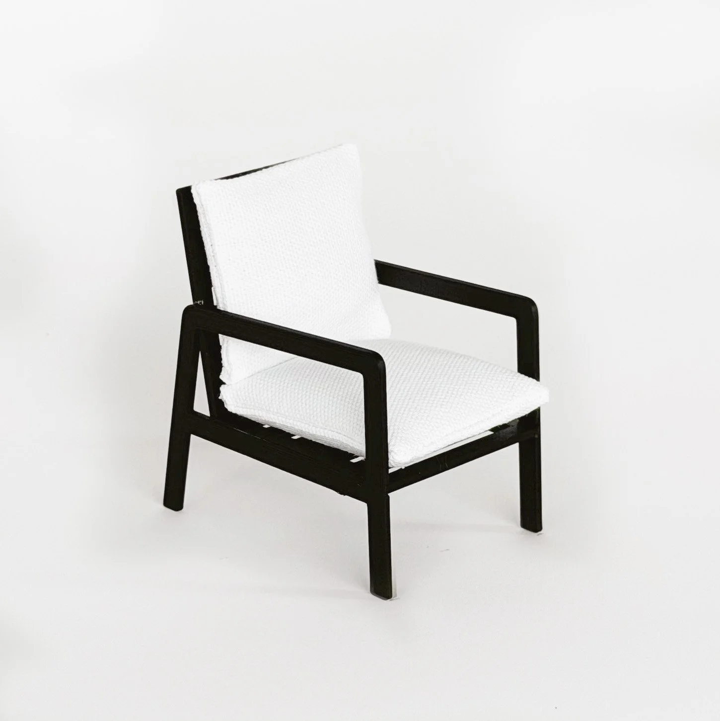 Side view of 1:12 scale modern dollhouse armchair with clean lines and minimalist silhouette