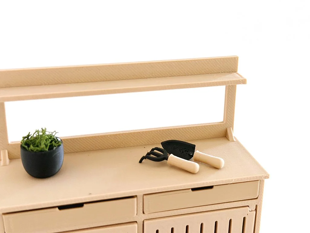 Close-up view of modern miniature garden tools designed for dollhouse garden and shed scenes.